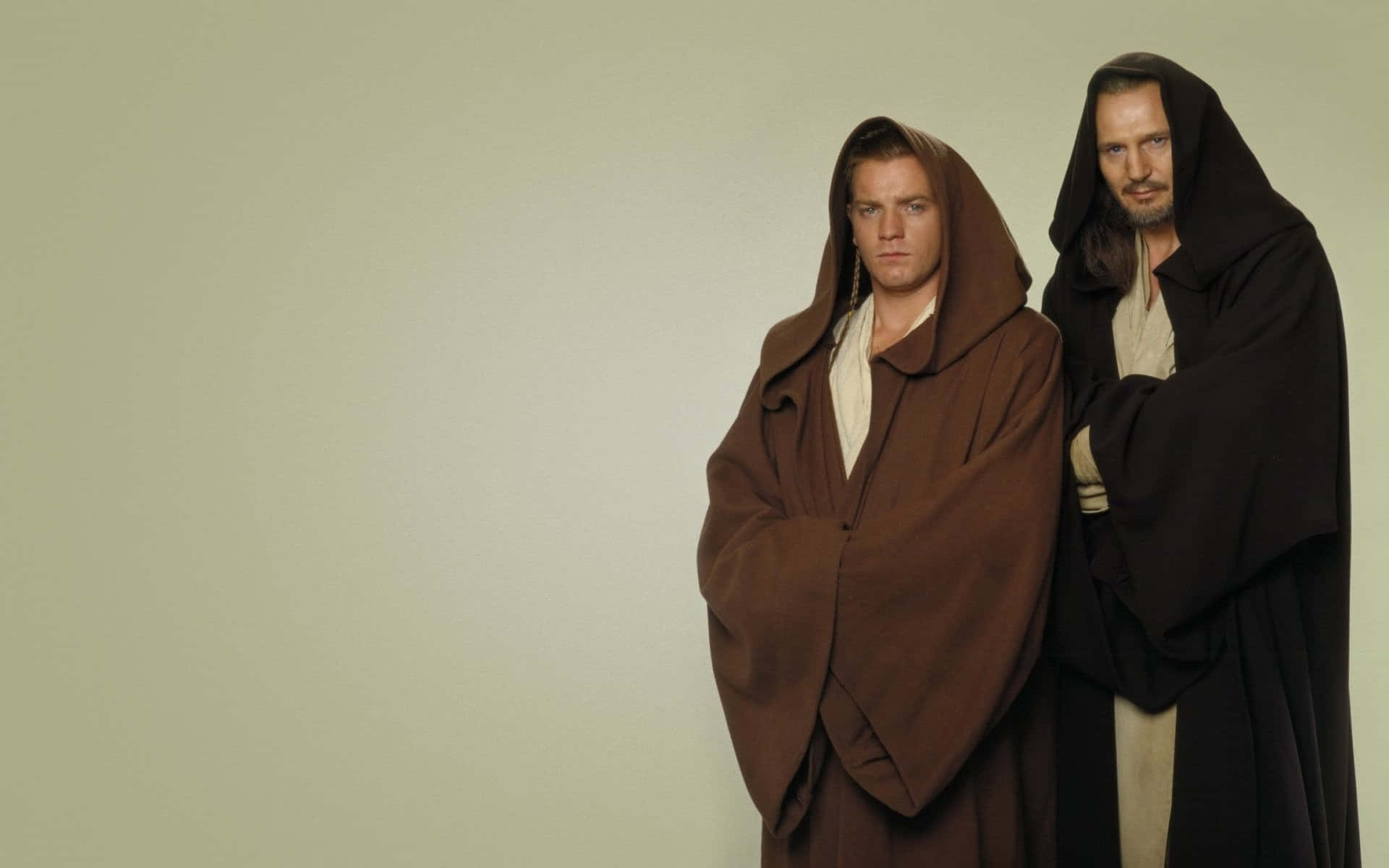 Qui-gon Jinn 桌布 壁紙 — 兩名身穿棕色和黑色長袍的絕地武士，表情嚴肅，莊嚴地站在純米色背景前。