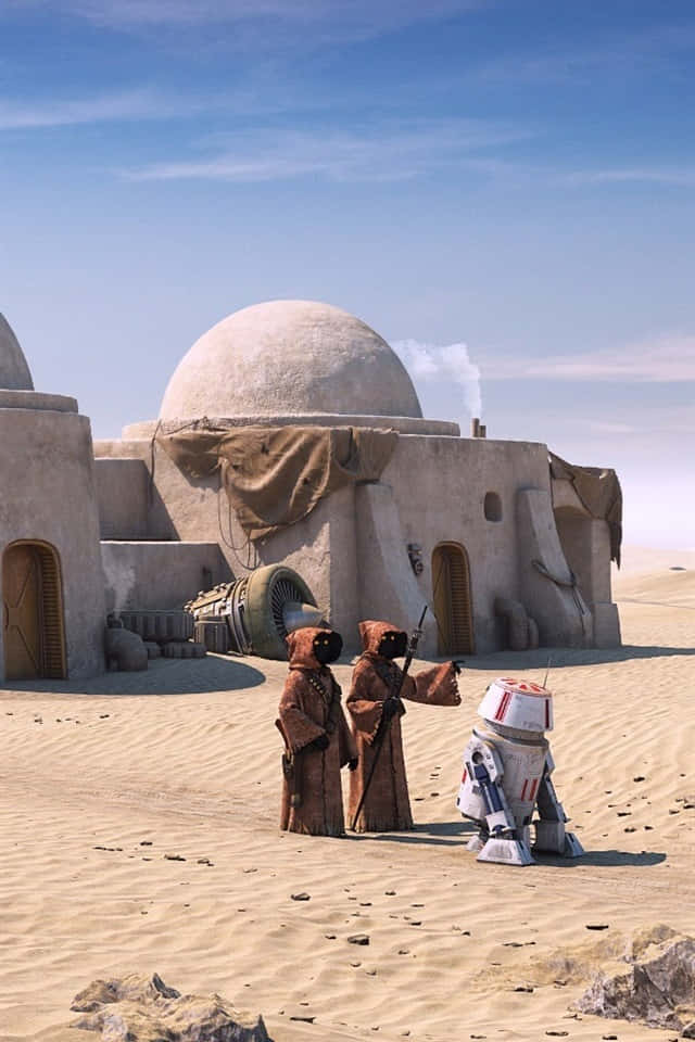 Tatooine 桌布 壁紙 — 兩名身穿棕色長袍的沙漠居民站在一個白色機器人旁邊，面前是一座圓頂砂岩住所，背景是清澈的藍天。