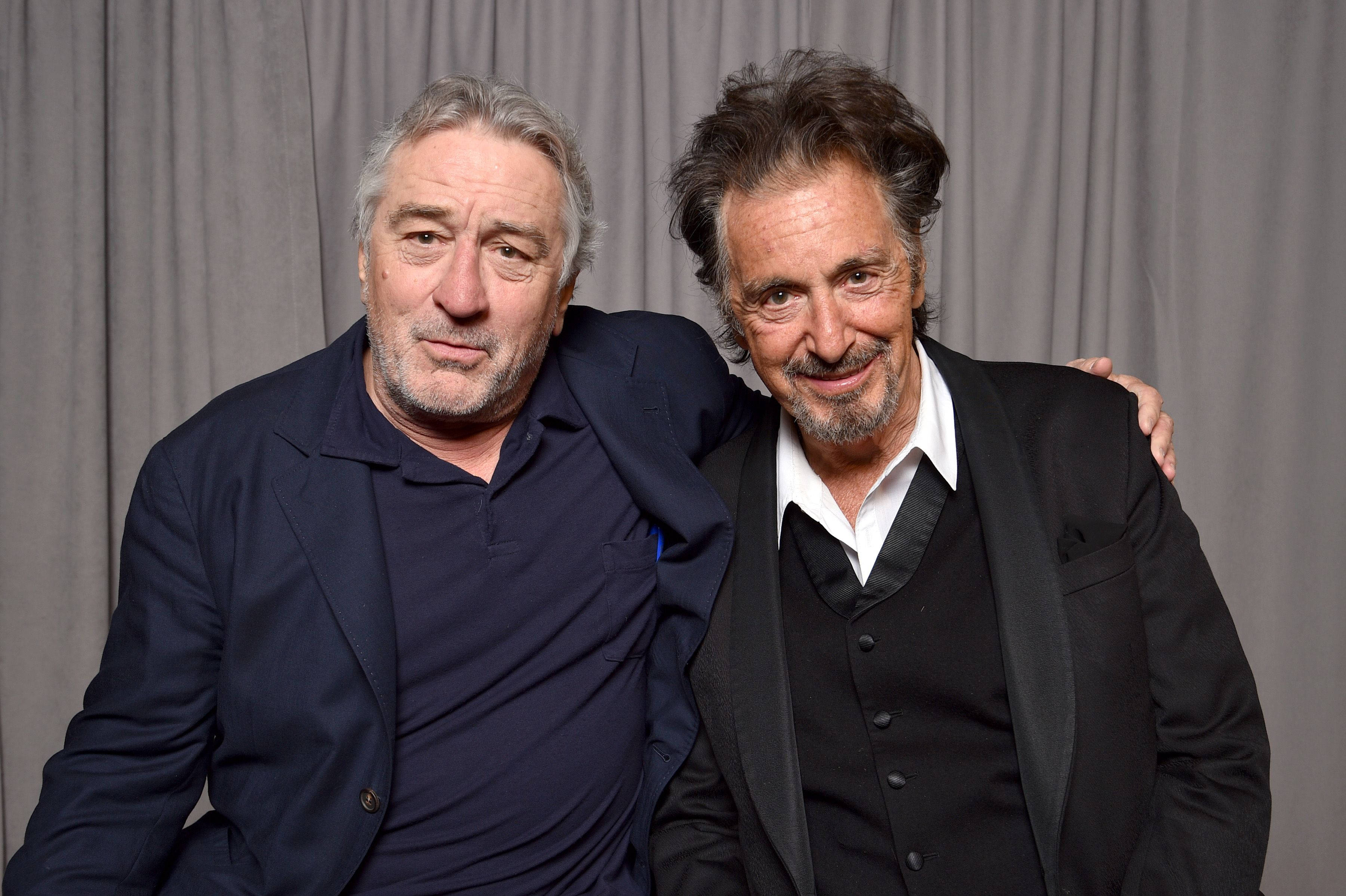 Robert De Niro 桌布 壁紙 — 兩名身穿正裝的男子在純灰色窗簾背景下溫馨地互相搭肩合影。