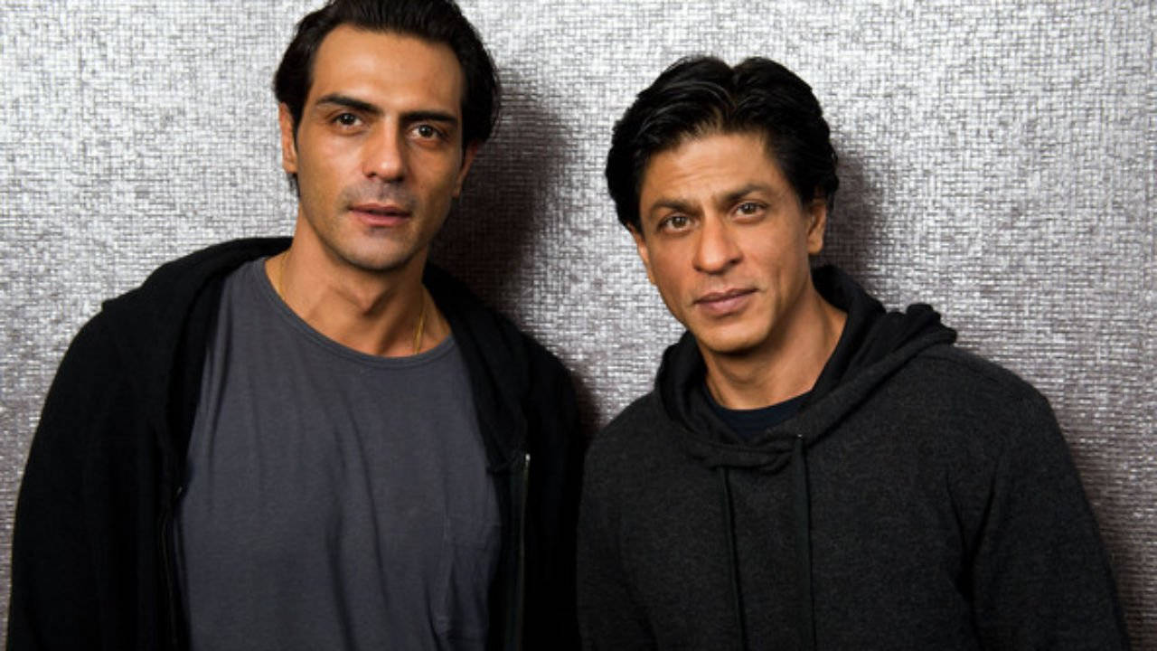Arjun Rampal 桌布 壁紙 — 兩名身穿深色休閒服的男子並肩站在有紋理的銀色牆壁前，表情嚴肅。