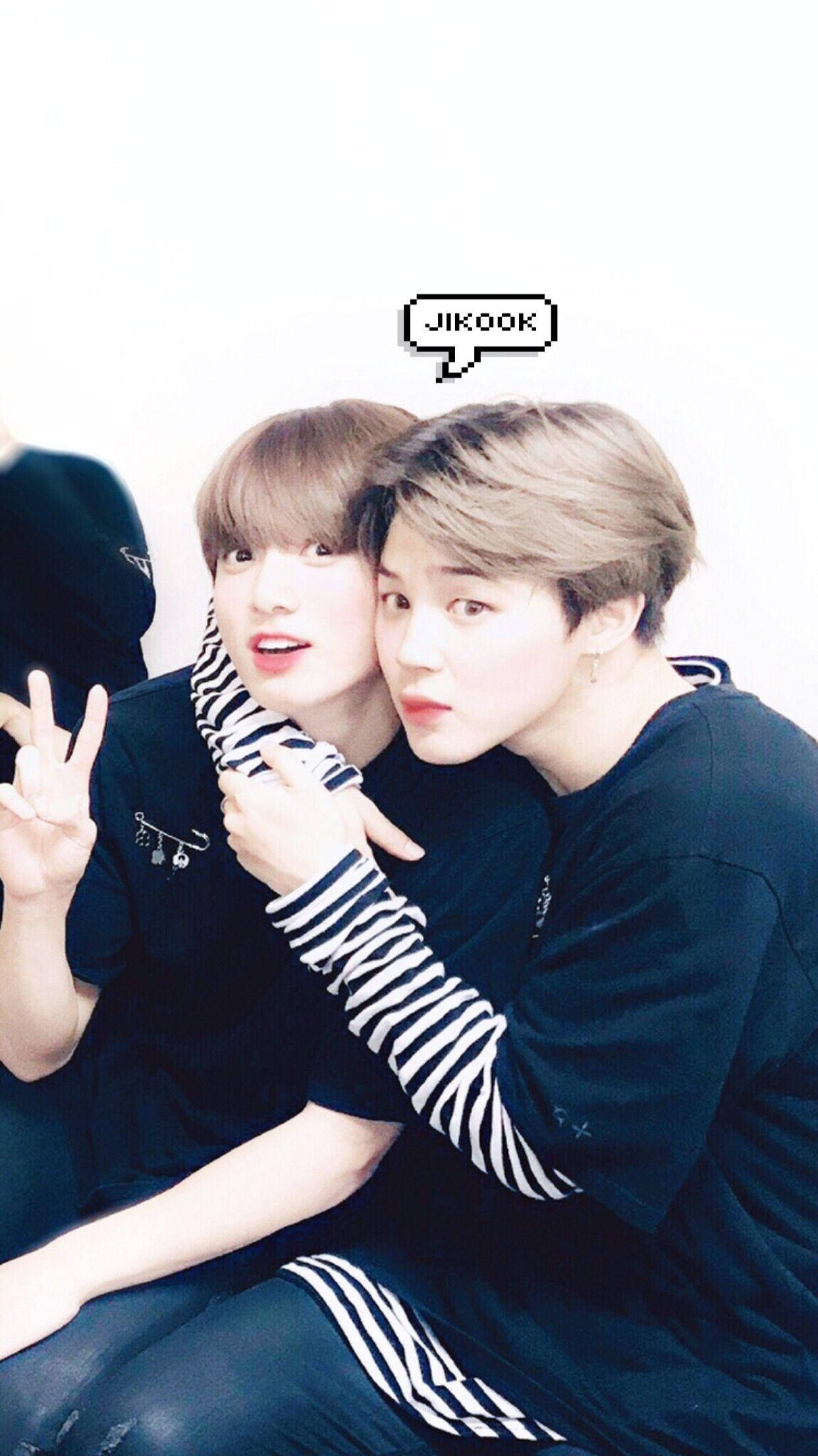 Jikook 桌布 壁紙 — 兩名身穿深色服裝的年輕男子在純白背景前緊密擺姿勢，一人比出和平手勢，另一人靠過來，帶有像素化對話框，寫著JIKOOK。