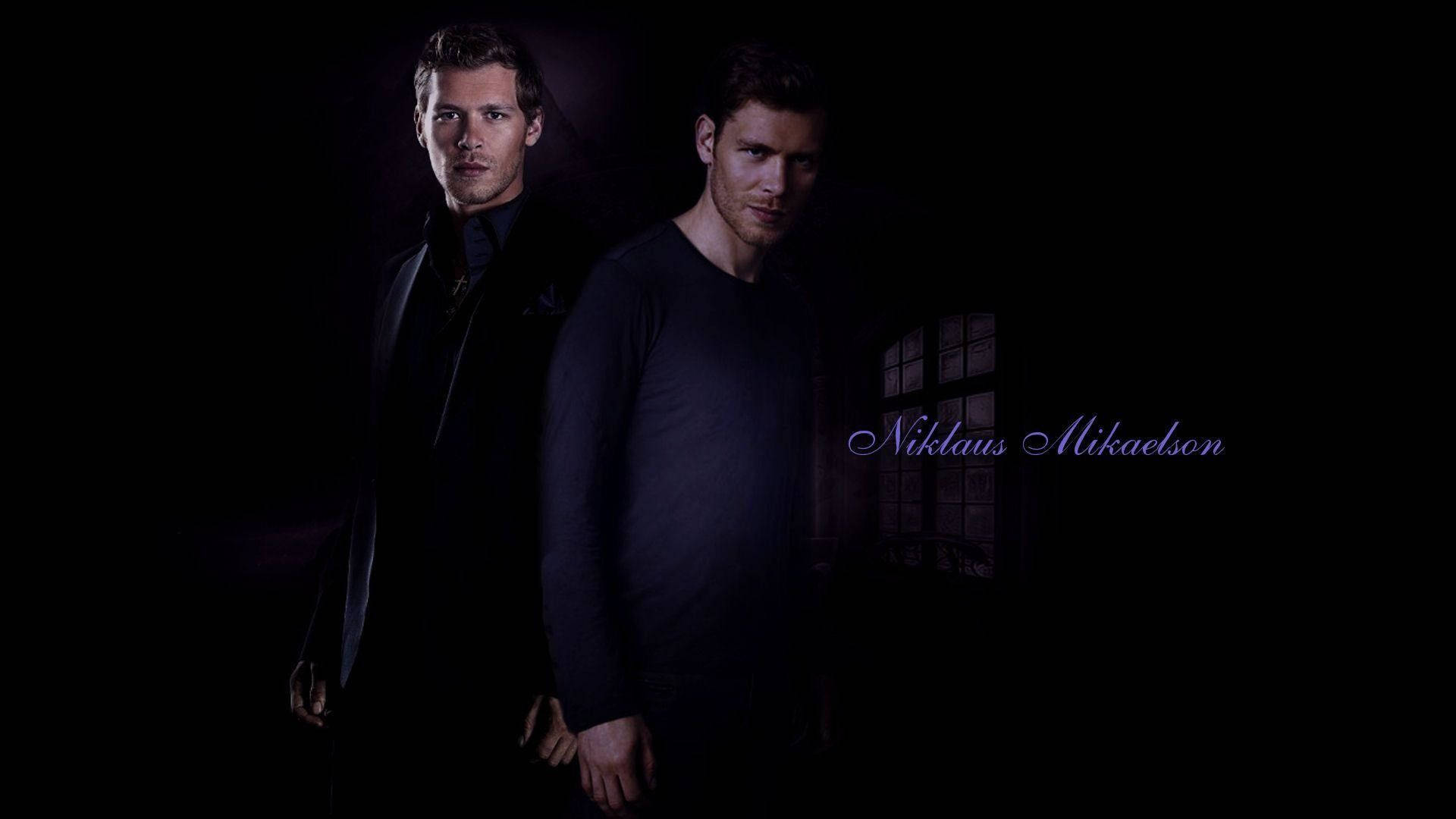 elijah mikaelson 桌布 壁紙 — 兩名身穿深色衣服的男子以陰影剪影站在黑色背景前，背後有微弱的窗光。