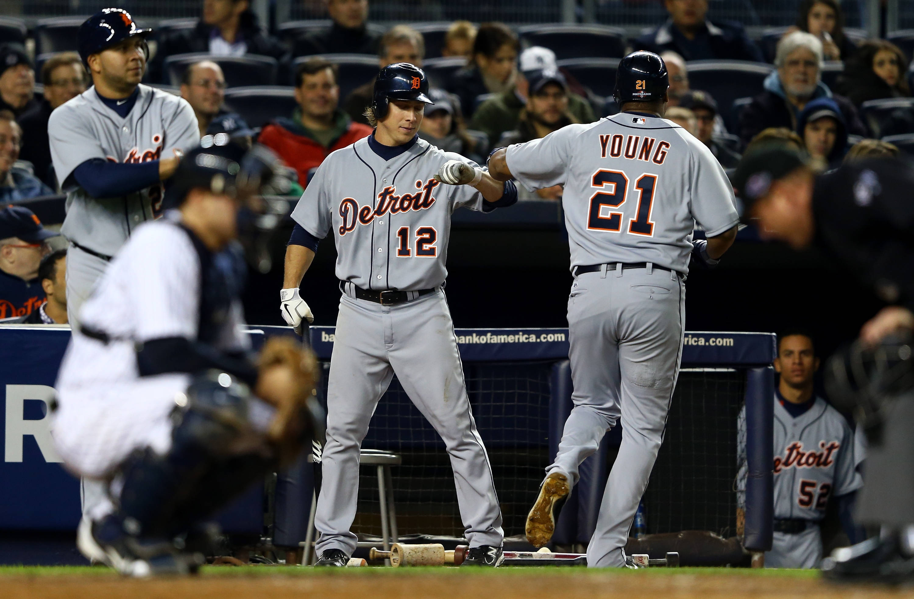 tigers 桌布 壁紙 — 兩名身穿灰色球衣的底特律老虎棒球選手在夜間比賽中於本壘板附近擊掌，背景有球迷。