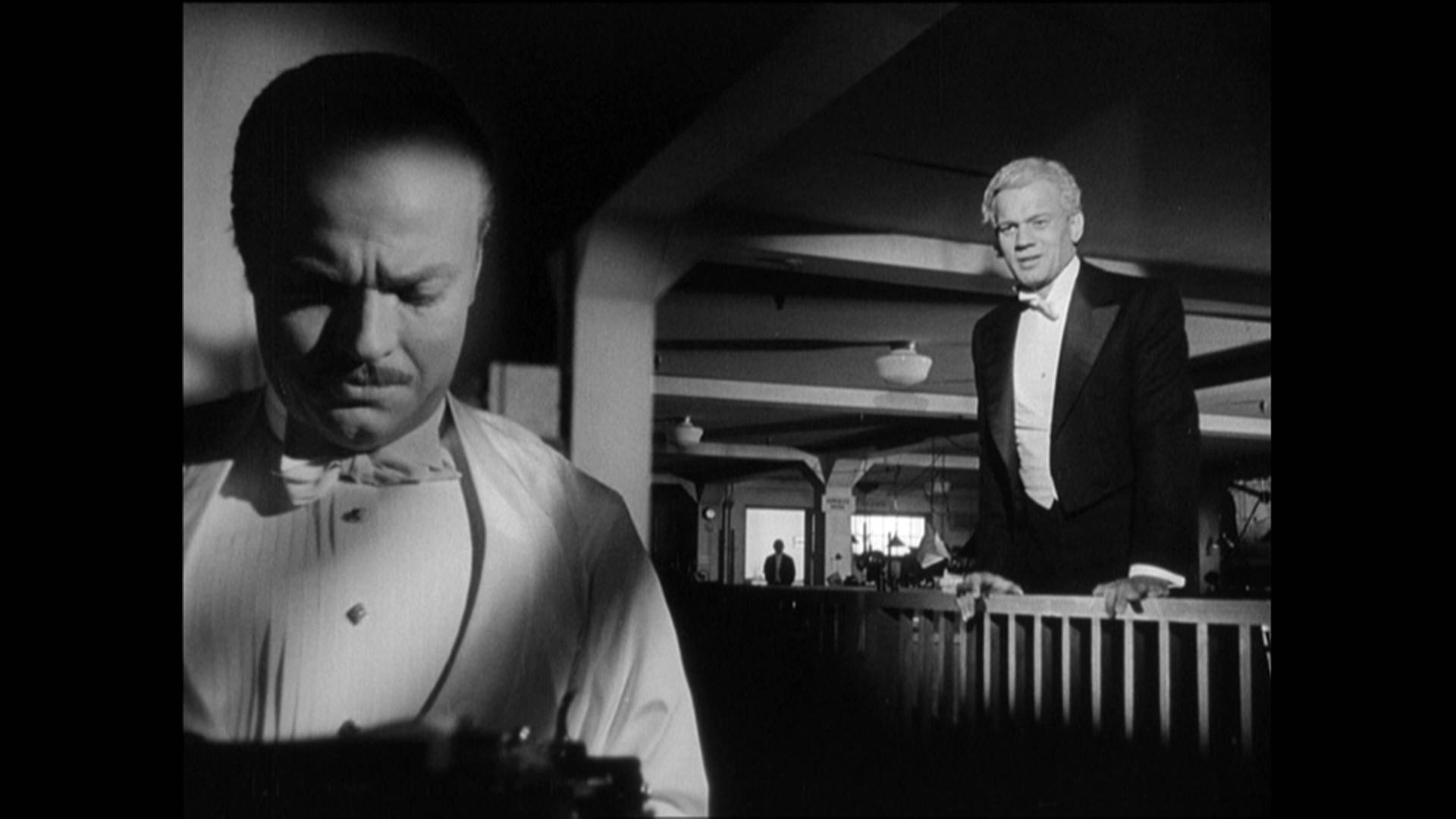 Citizen Kane 桌布 壁紙 — 兩名身穿燕尾服的男士站在光線昏暗的室內環境中，帶有戲劇性的明暗對比燈光效果。