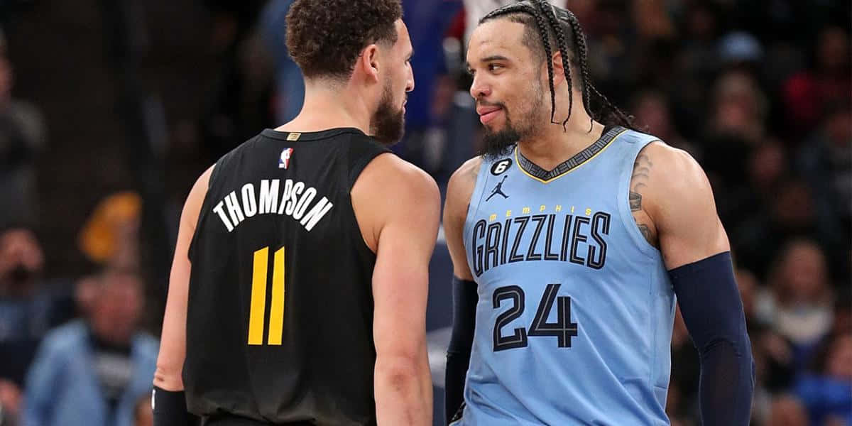 Dillon Brooks 桌布 壁紙 — 兩名身穿球衣的籃球運動員在比賽中面對面，背景是模糊的人群。