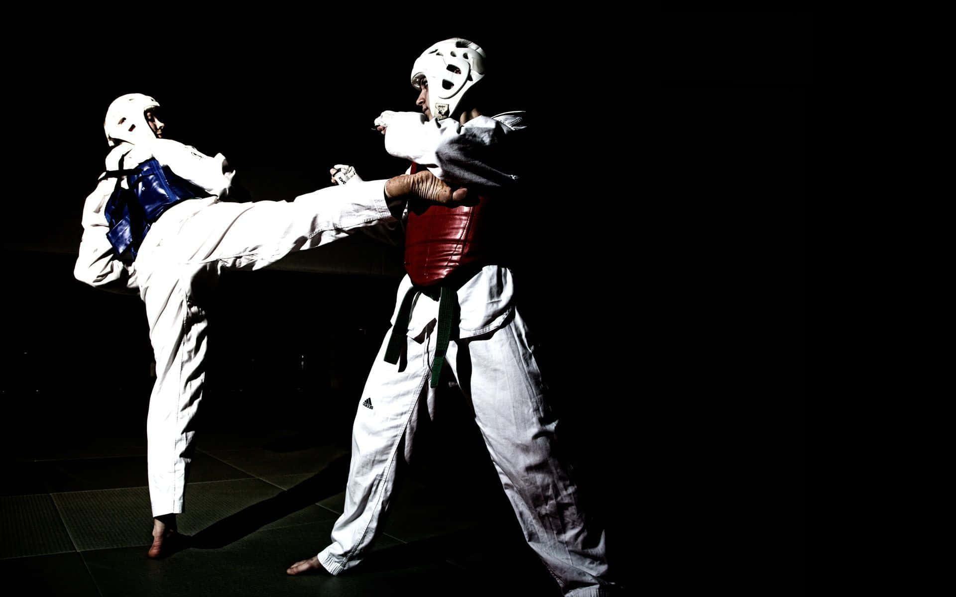Martial Arts Uniform 桌布 壁紙 — 兩名身穿白色制服和護具的跆拳道選手在戲劇性的高對比度工作室拍攝中碰撞，其中一人踢出強力一腳。