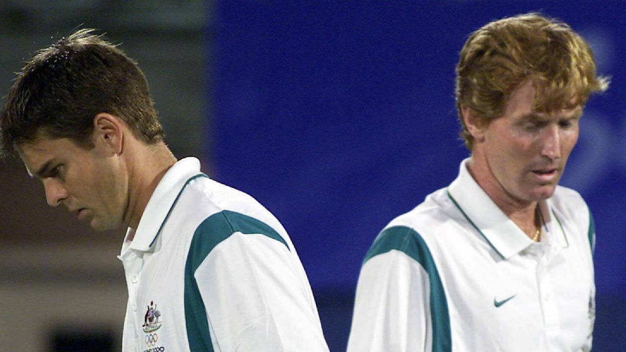 Tennis 桌布 壁紙 — 兩名身穿白色及青綠色奧運制服的男網球選手在藍色背景下顯得沮喪。