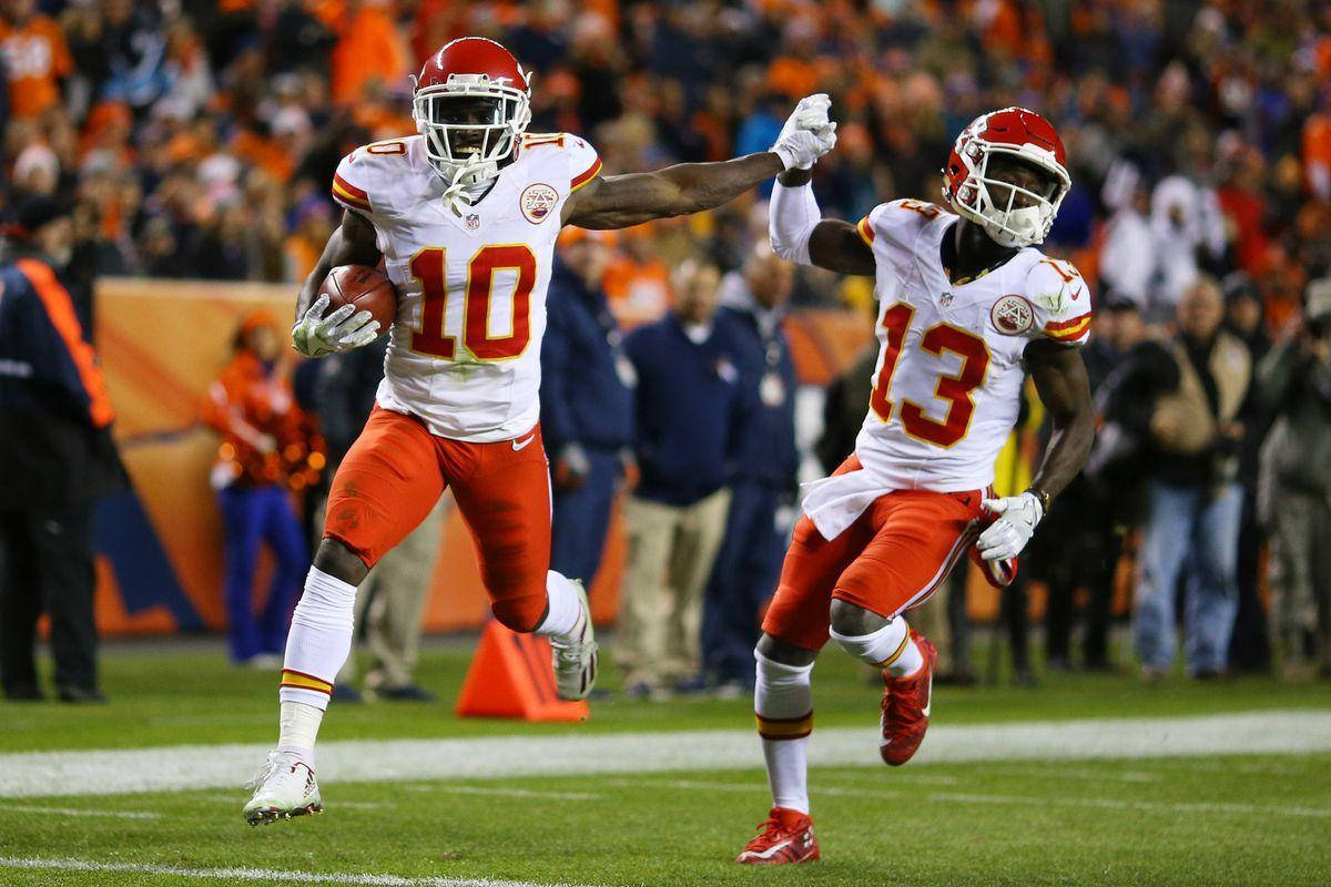 Tyreek Hill 桌布 壁紙 — 兩名身穿白色和橙色球衣的堪薩斯城酋長隊美式足球員在燈光球場上慶祝達陣，背景有球迷。