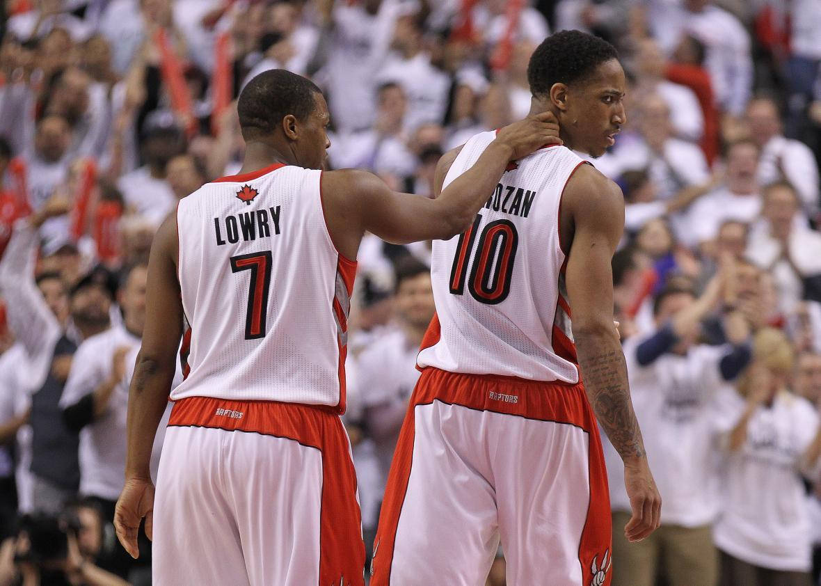Lowry 桌布 壁紙 — 兩名身穿白色和紅色球衣的籃球運動員在球場上擁抱，身後是歡呼的人群。