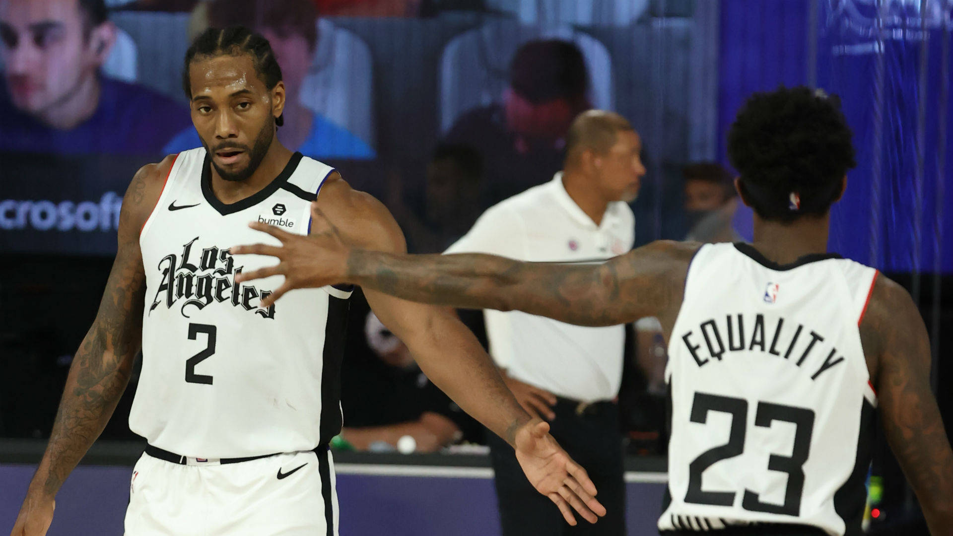 Lou Williams 桌布 壁紙 — 兩名身穿白色洛杉磯球衣的籃球運動員在明亮的場館燈光下比賽中擊掌。