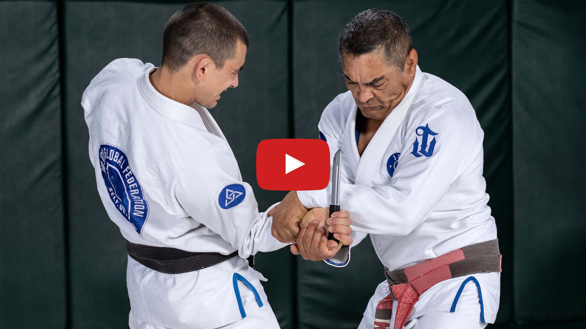 martial arts 桌布 壁紙 — 兩名身穿白色道服的武術家在受控的訓練環境中激烈地纏鬥，手持一把刀。