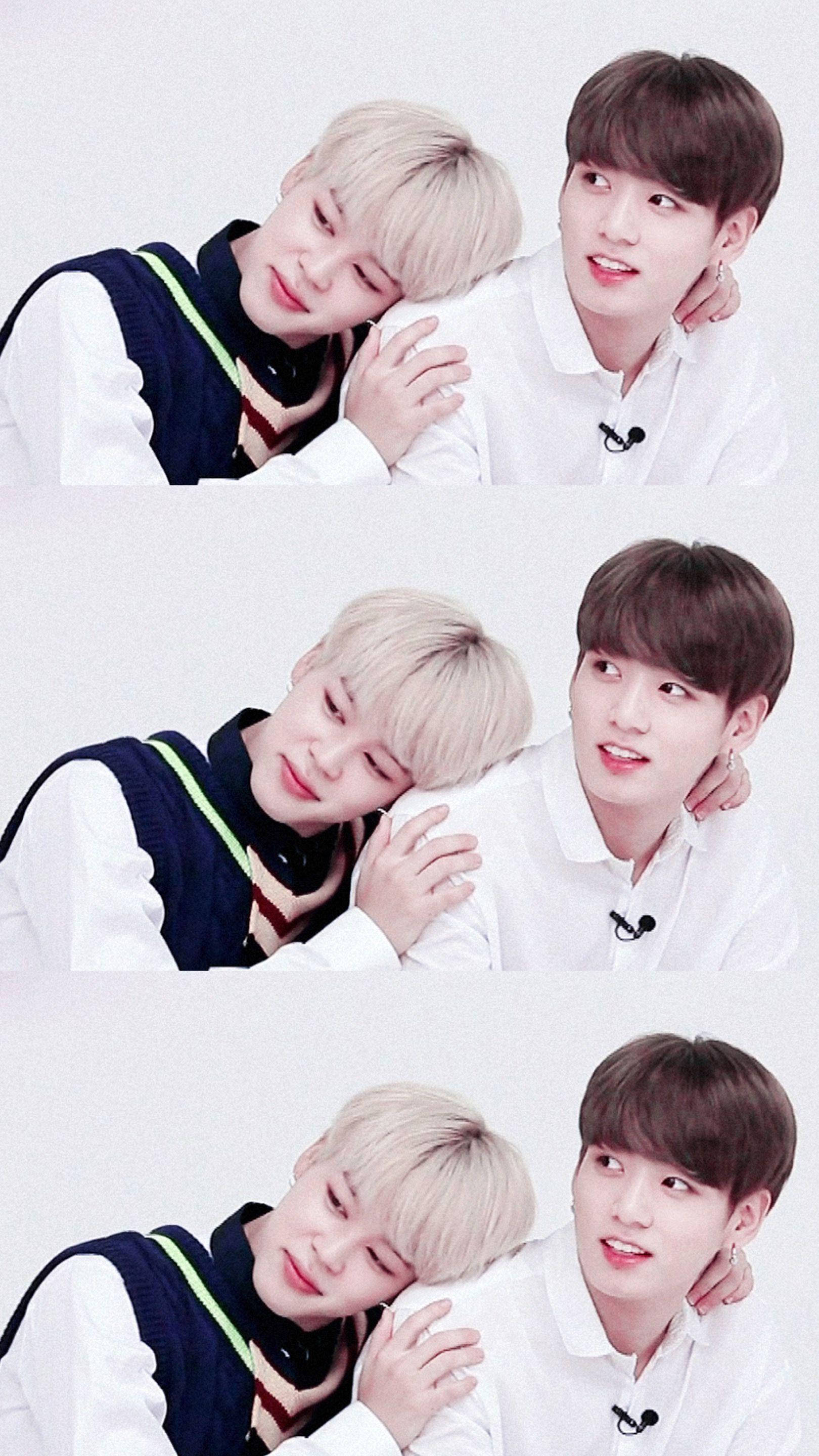 Jikook 桌布 壁紙 — 兩名身穿白襯衫和深藍色背心的年輕男子在純白背景前分享溫柔親密的時刻。