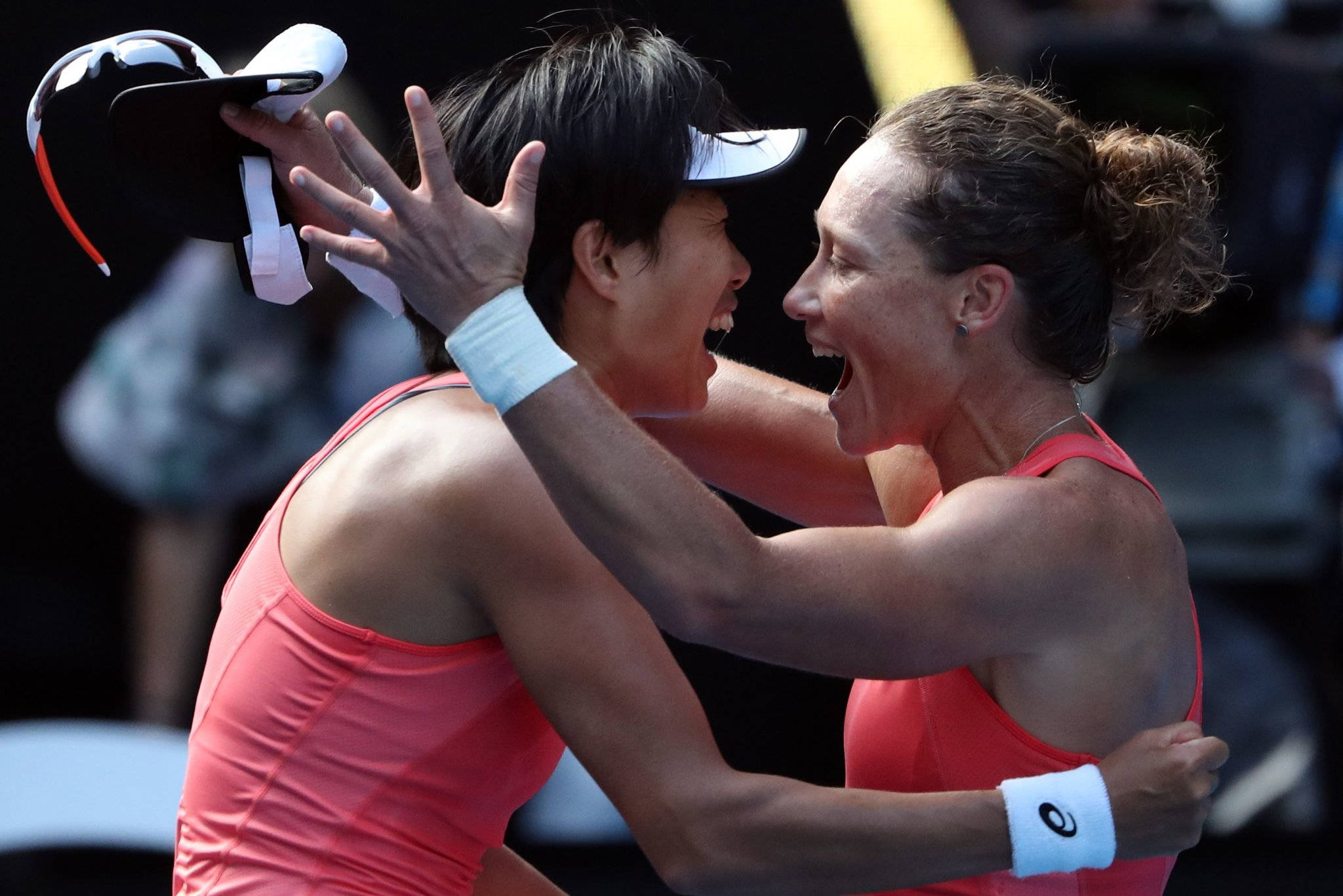Champion 桌布 壁紙 — 兩名身穿粉紅色同款球衣的女網球選手在比賽勝利後擁抱並歡呼。