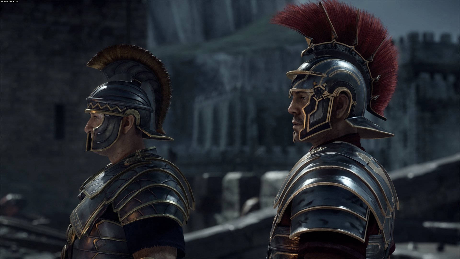 rome 2 桌布 壁紙 — 兩名身穿精細金屬盔甲、頭戴紅色和棕色羽飾的羅馬士兵，以石堡為背景，側面站立。