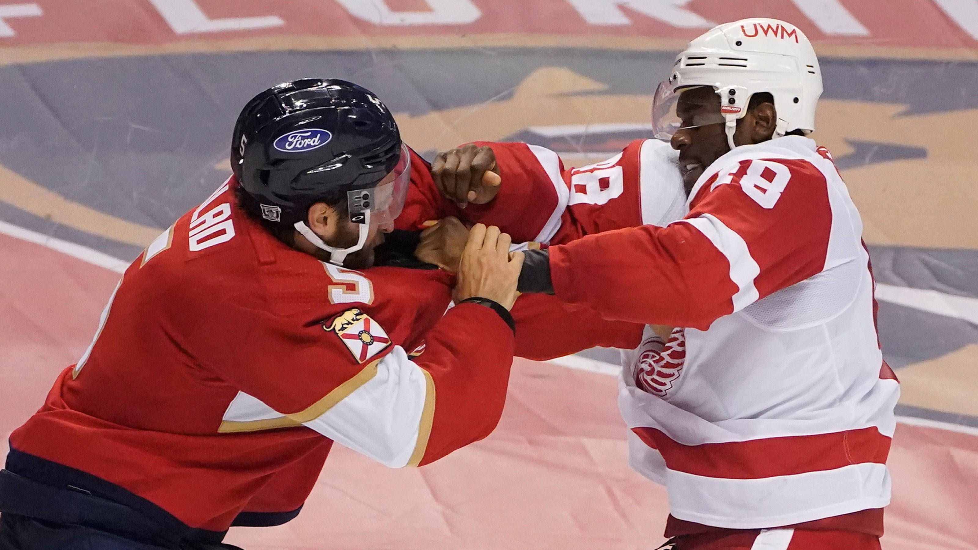 hockey 桌布 壁紙 — 兩名身穿紅白球衣的冰上曲棍球運動員在比賽中於冰上激烈纏鬥。