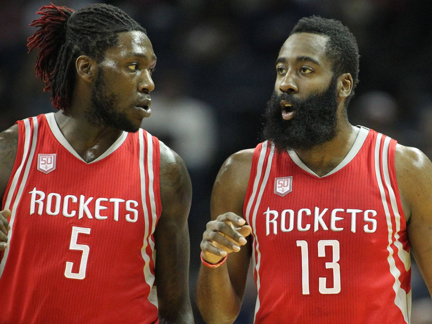 montrezl harrell 桌布 壁紙 — 兩名身穿紅色球衣的休士頓火箭籃球運動員在明亮的場館燈光下於比賽中激烈交談。
