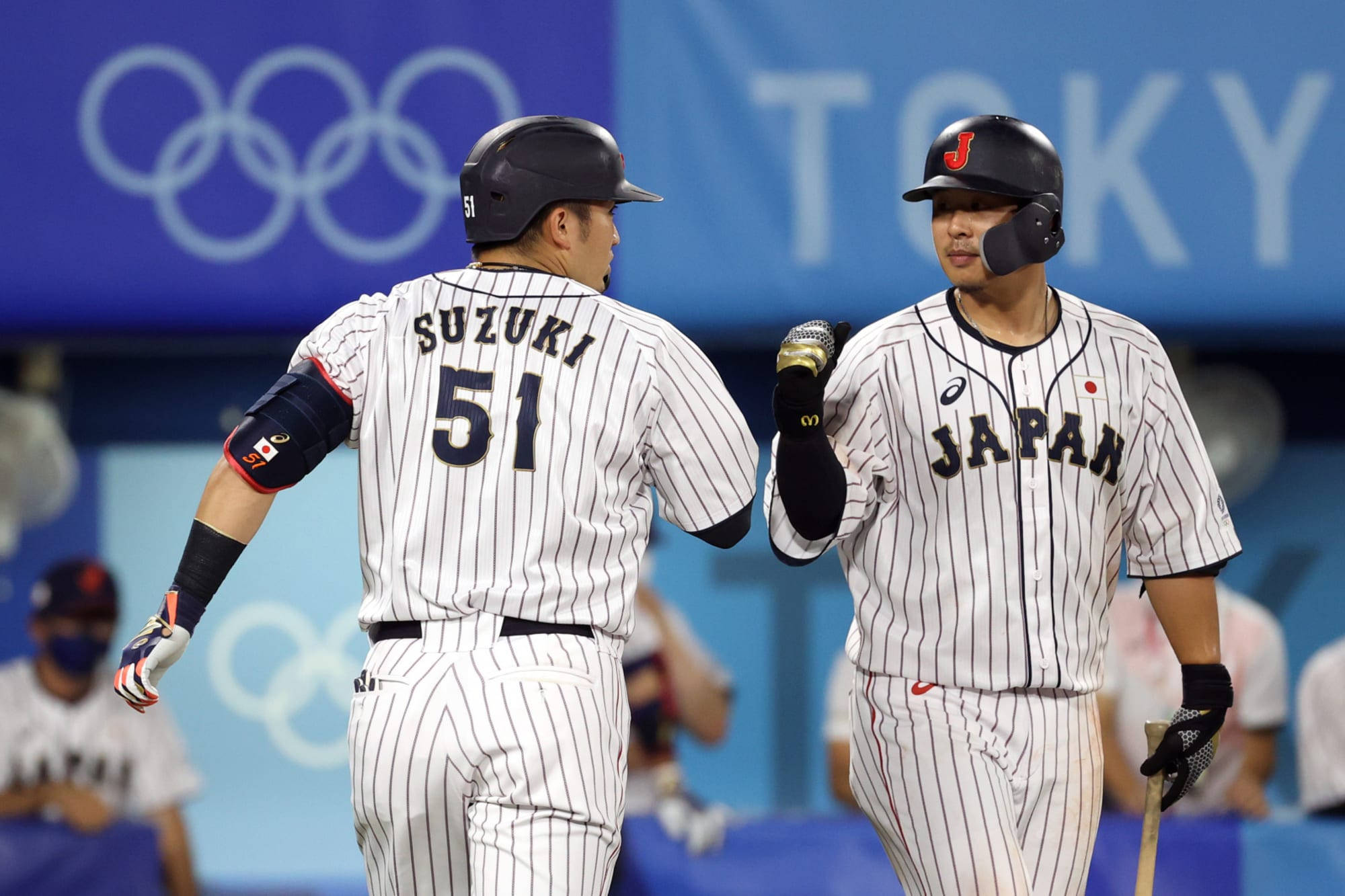 運動 桌布 壁紙 — 兩名身穿細條紋球衣的日本棒球選手在東京奧運會的體育場上擊掌。