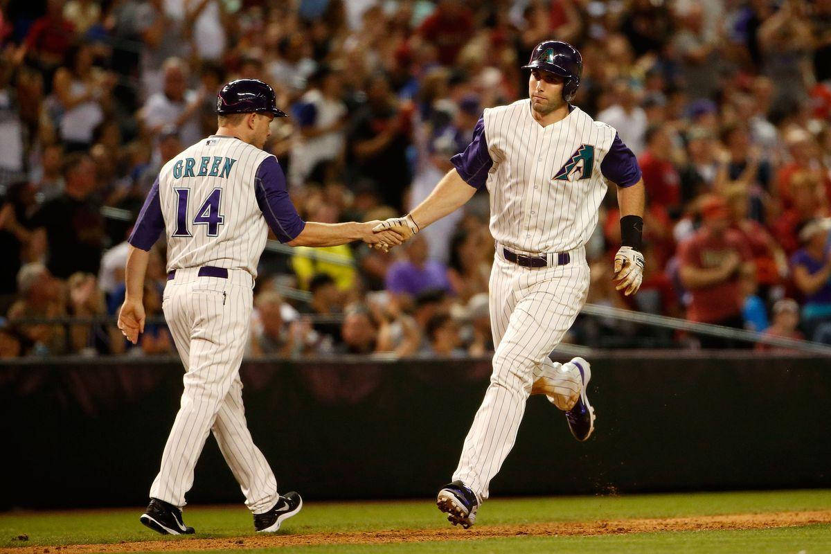 Paul Goldschmidt 桌布 壁紙 — 兩名身穿細條紋球衣的棒球運動員在球場燈光下的泥土壘道上握手，身後是模糊的人群。
