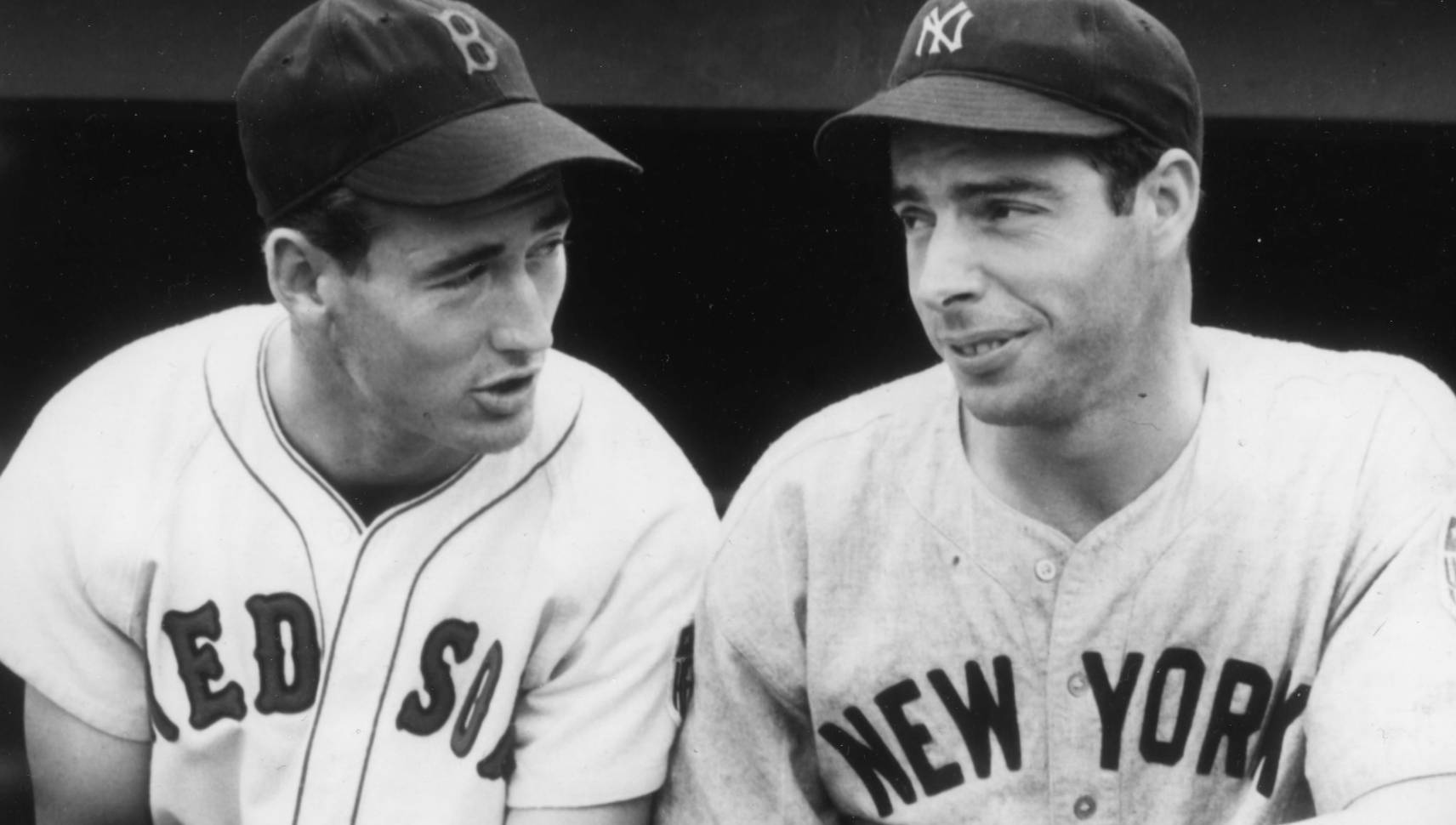 Joe Dimaggio 桌布 壁紙 — 兩名身穿經典制服的復古棒球運動員在球員休息區分享自然一刻。
