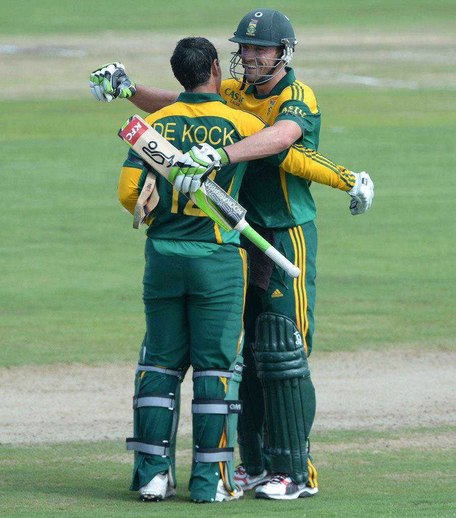 quinton de kock 桌布 壁紙 — 兩名身穿綠色和黃色球衣的南非板球運動員在比賽結束後於草地上擁抱。
