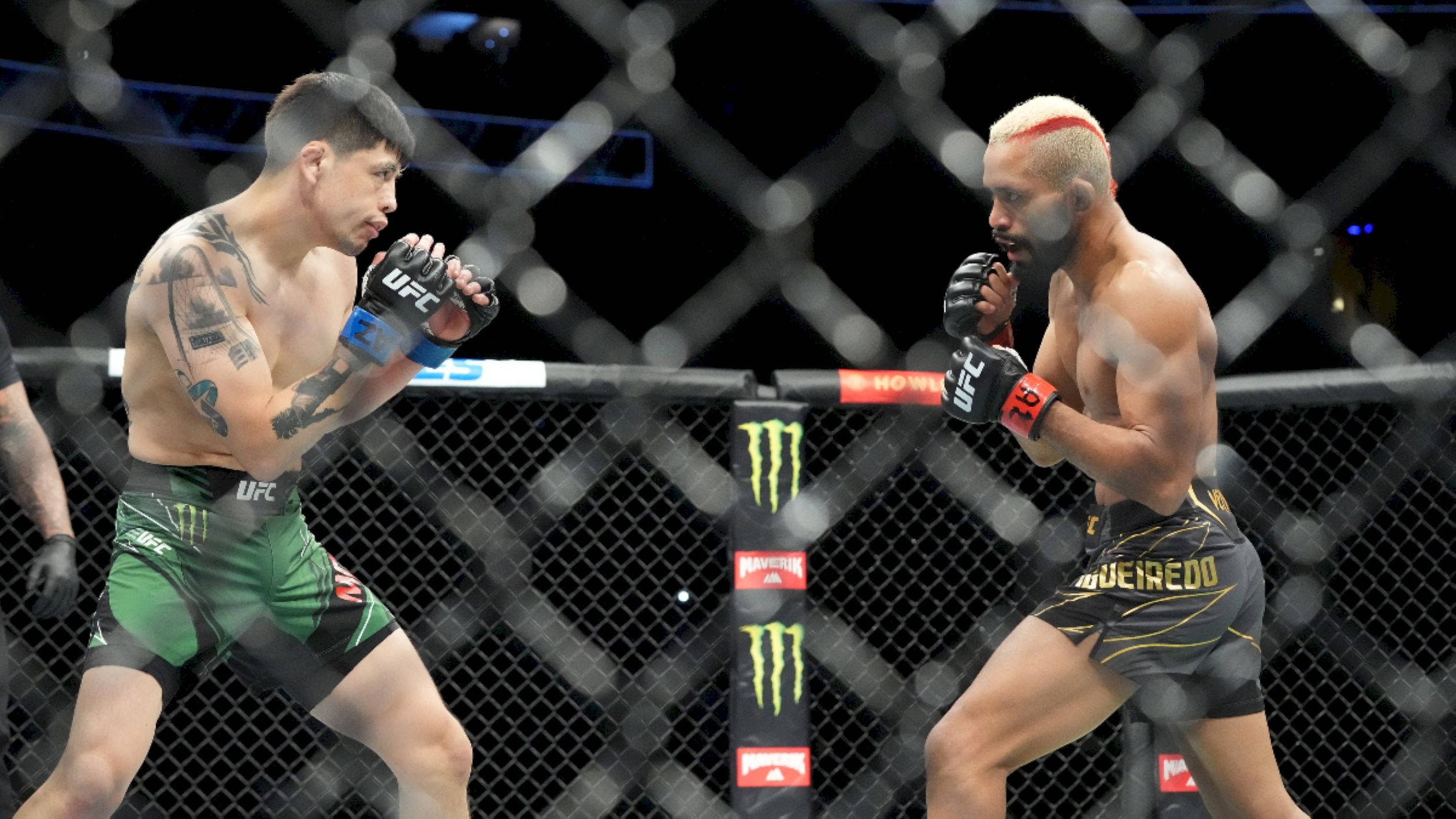 MMA 桌布 壁紙 — 兩名身穿綠色和黑色短褲的MMA拳手在明亮的競技場燈光下於UFC八角籠內對峙。