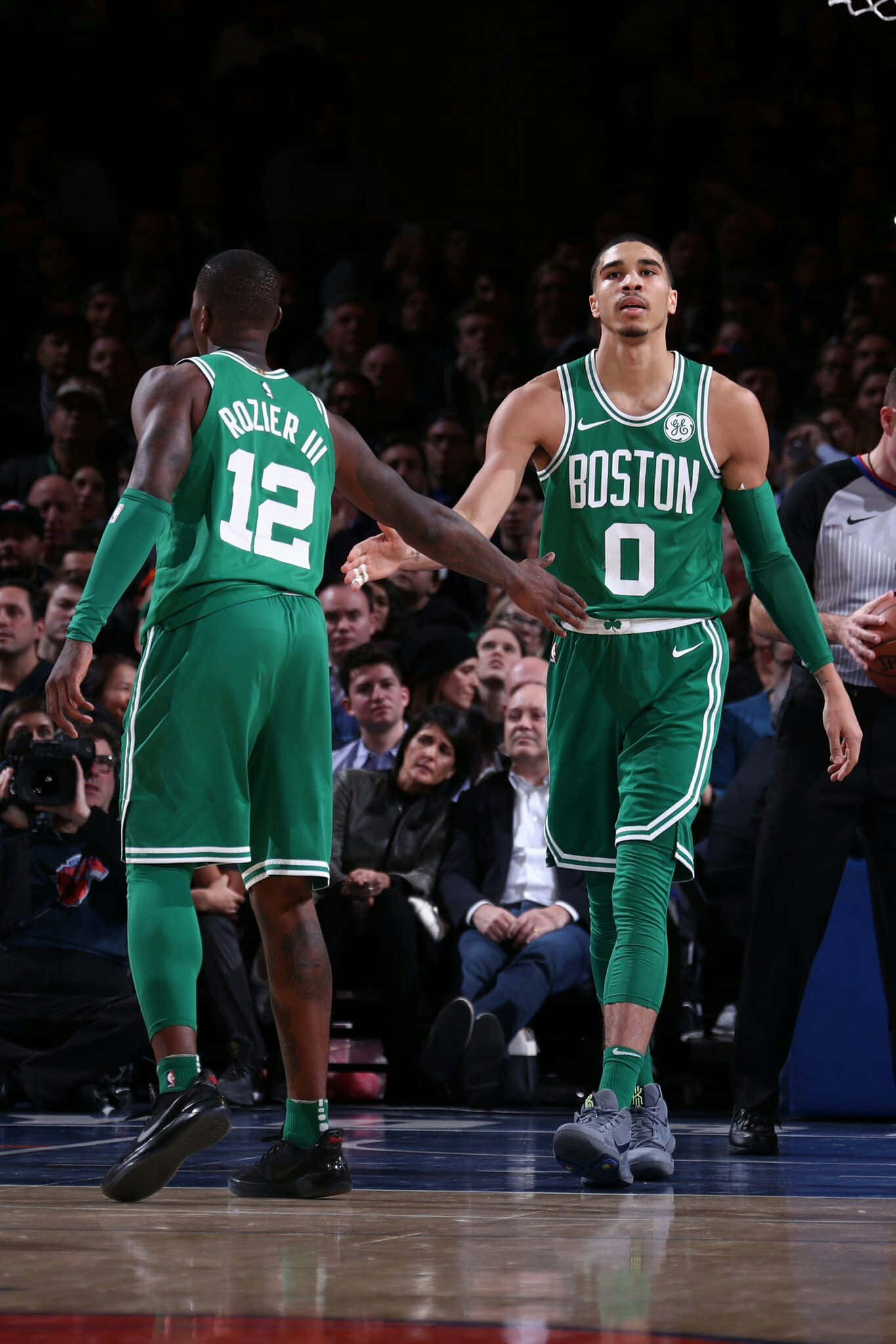 NBA 桌布 壁紙 — 兩名身穿綠色球衣的波士頓塞爾提克籃球運動員在場館燈光下，於光滑的球場上擊掌。