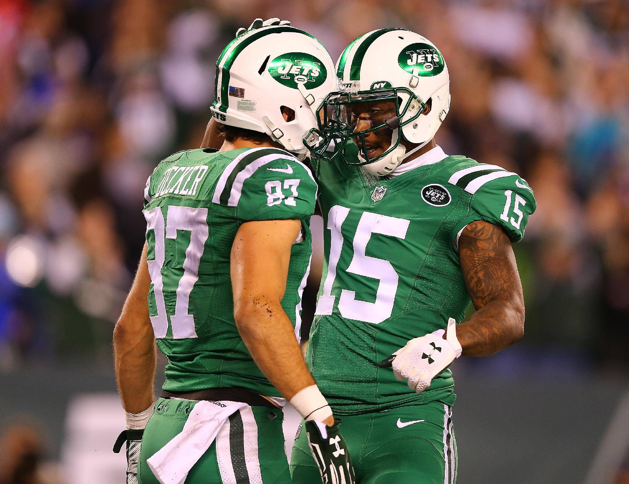 Ny Jets 桌布 壁紙 — 兩名身穿綠色球衣的紐約噴射機美式足球員在燈光球場上頭盔相碰慶祝一次進攻。
