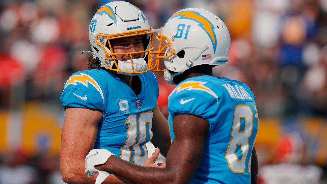 運動 桌布 壁紙 — 兩名身穿藍白電光隊球衣的NFL美式足球員在陽光明媚的日間比賽中在球場上擁抱。