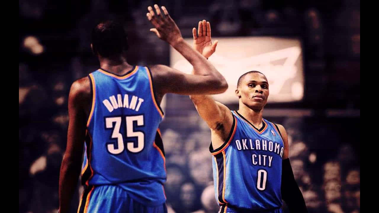 兩名身穿藍色球衣的籃球運動員在比賽中擊掌。 — NBA 壁紙
