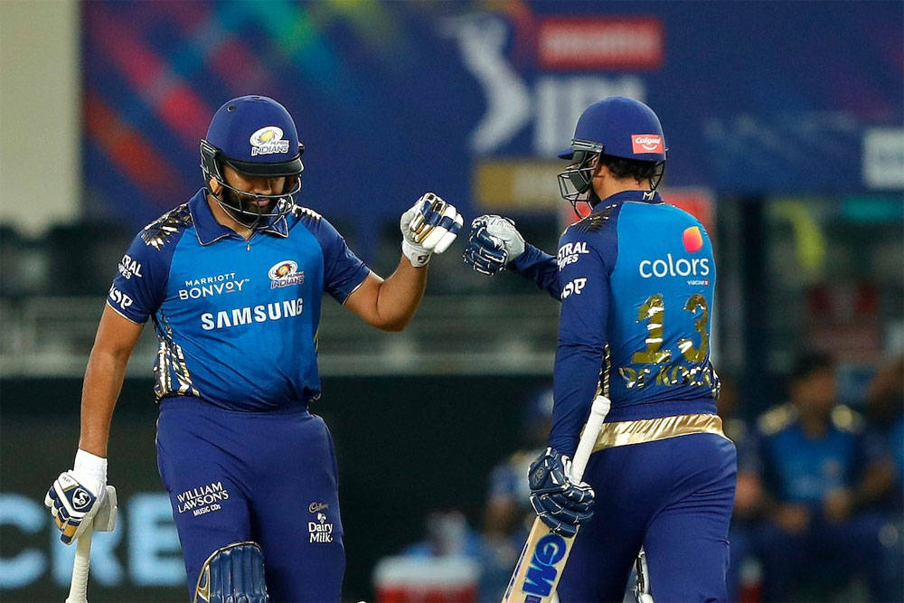 Mumbai Indians 桌布 壁紙 — 兩名身穿藍色球衣的板球運動員在夜間燈光明亮的球場上擊掌慶祝。