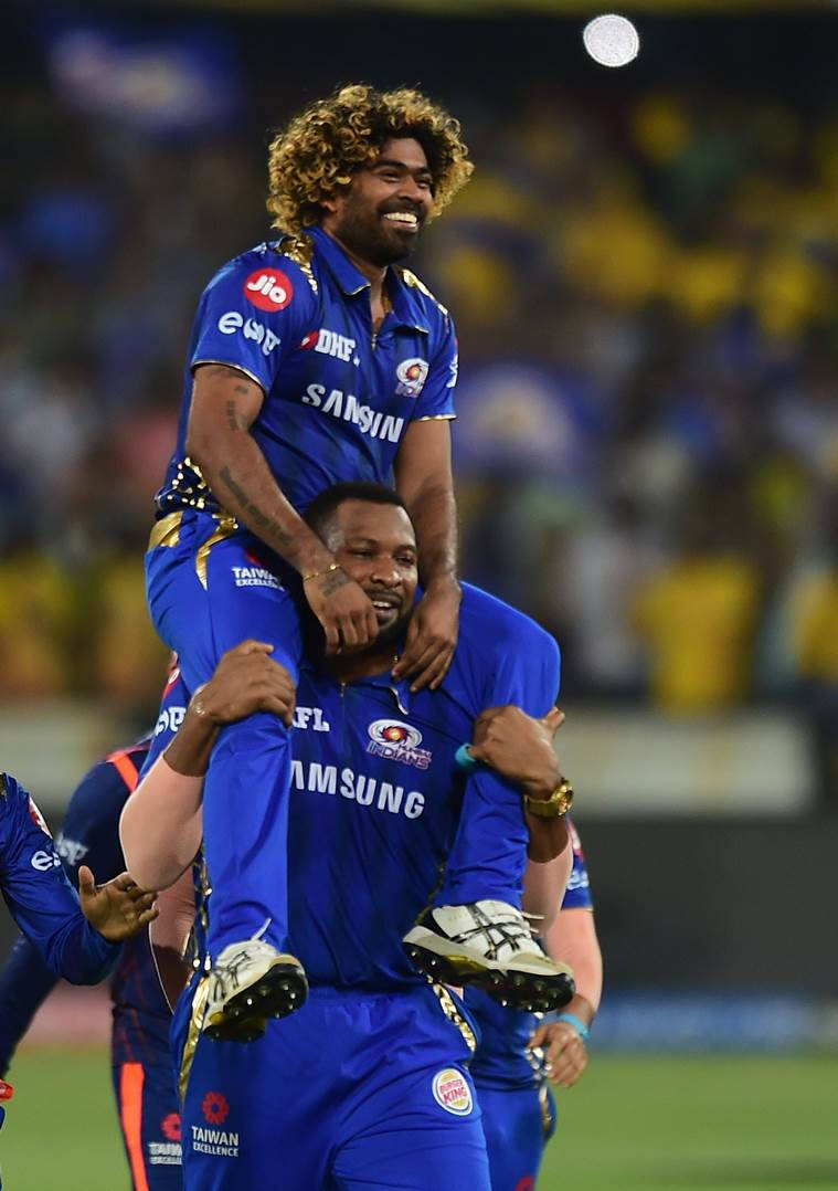 Mumbai Indians 桌布 壁紙 — 兩名身穿藍色球衣的板球運動員在體育場燈光下歡樂慶祝，其中一人騎在另一人背上。