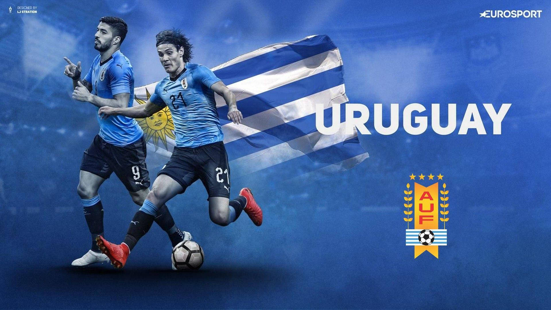 Uruguay 桌布 壁紙 — 兩名身穿藍色球衣的烏拉圭足球員在飄揚的旗幟背景下，在粗體「URUGUAY」文字下帶球衝刺。