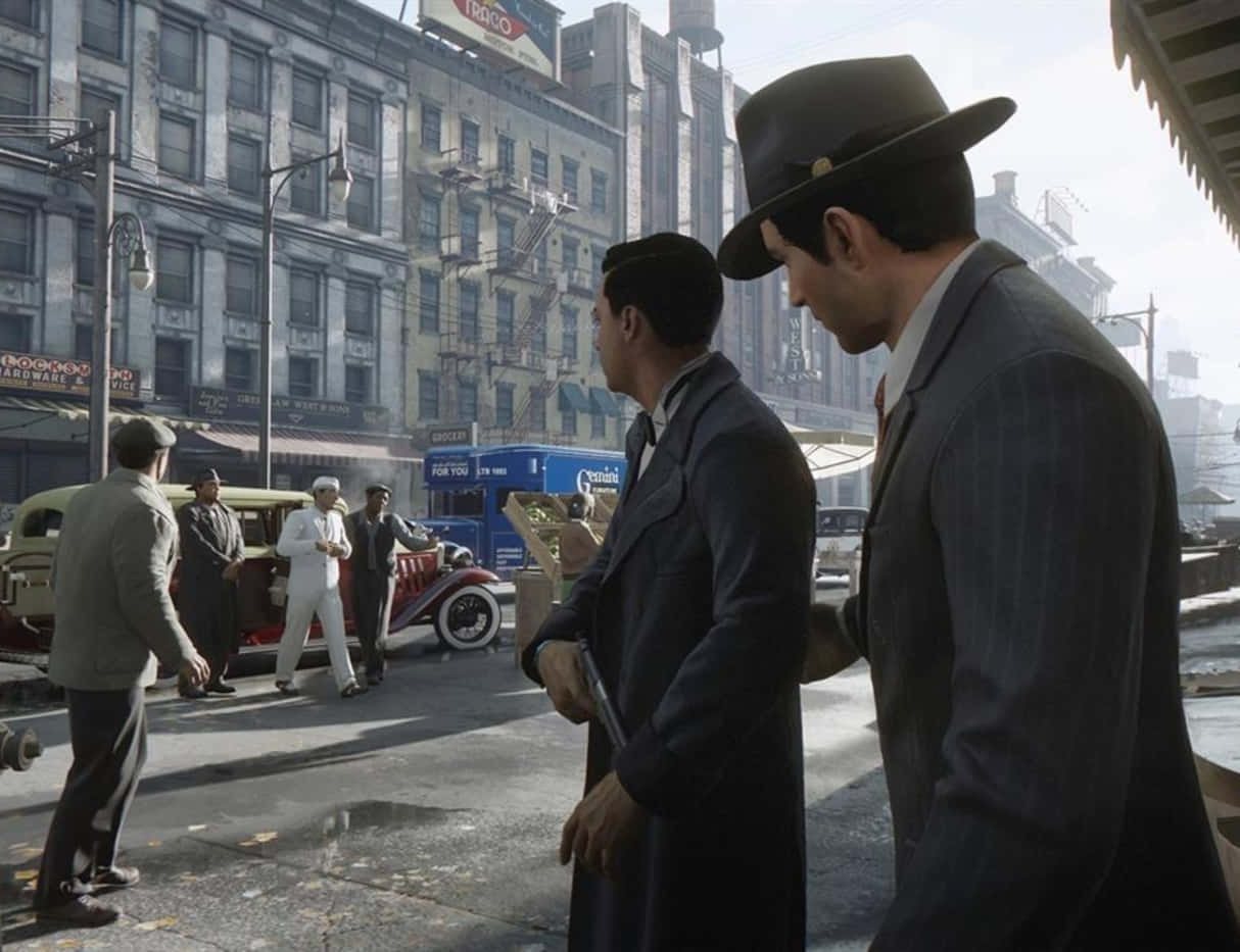 Mafia 桌布 壁紙 — 兩名身穿西裝戴帽子的男子在陽光明媚的1930年代城市街道上交談，街道上有復古汽車和磚砌建築。