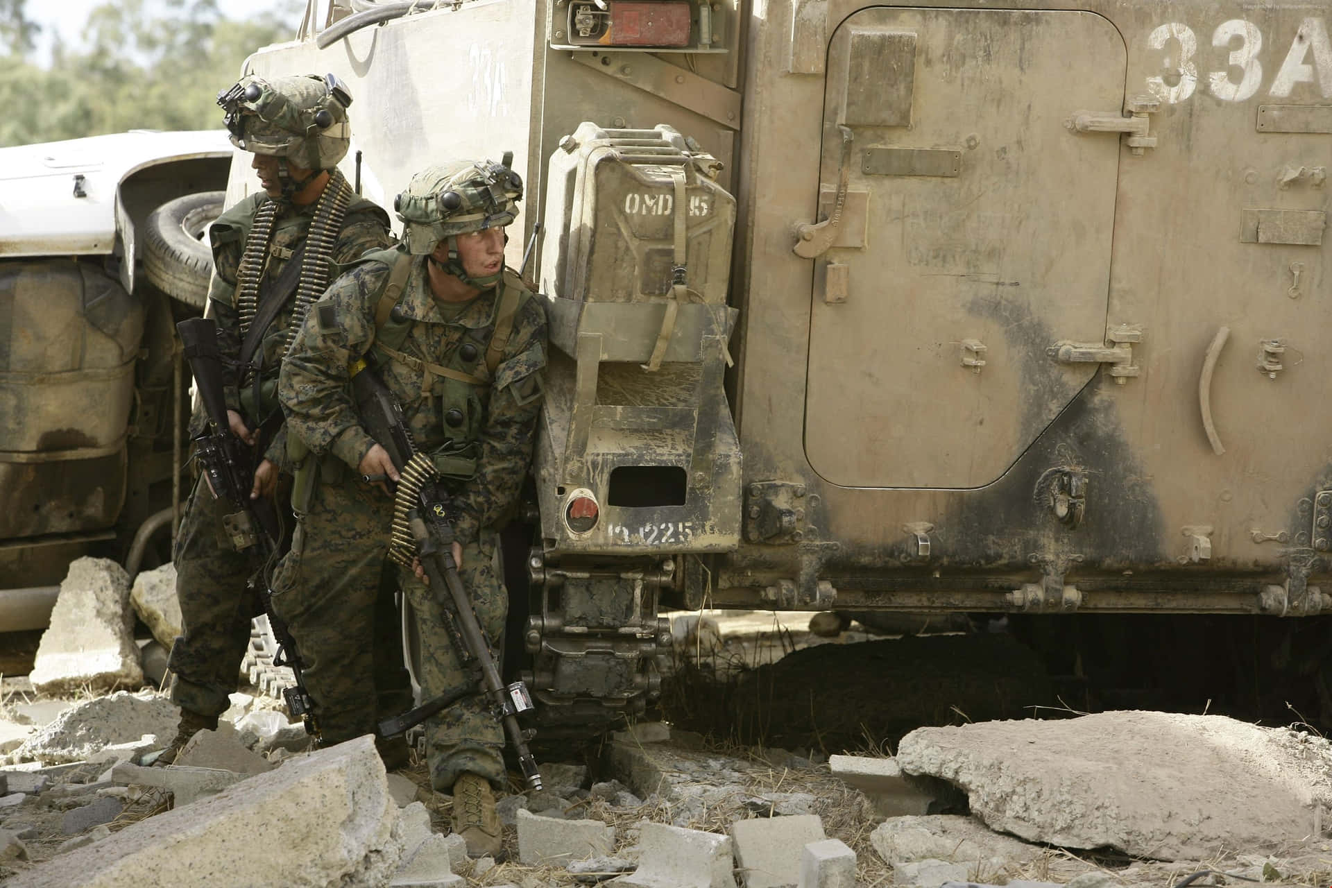  壁紙 — 兩名身穿迷彩裝備的士兵站在一輛佈滿灰塵的軍用卡車旁，周圍是瓦礫，在明亮的日光下。