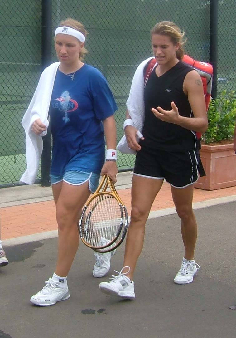 Svetlana Kuznetsova 桌布 壁紙 — 兩名身穿運動裝備的女網球選手在球場旁邊行走，一人拿著球拍，另一人正在交談中做手勢。