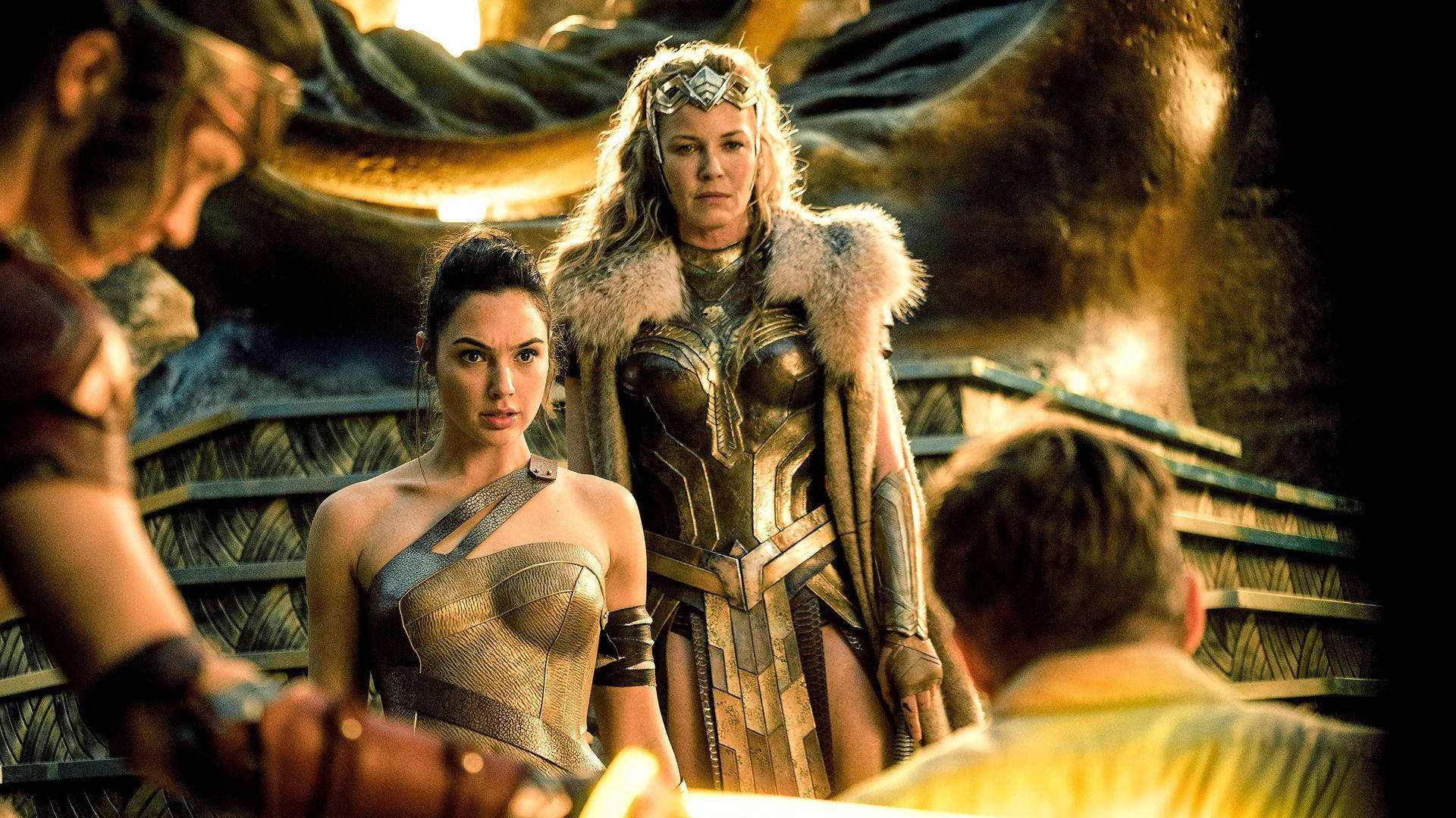 Wonder Woman 桌布 壁紙 — 兩名身穿鎧甲的女戰士站在光線昏暗的神殿中，身後有金色雕像和石階。