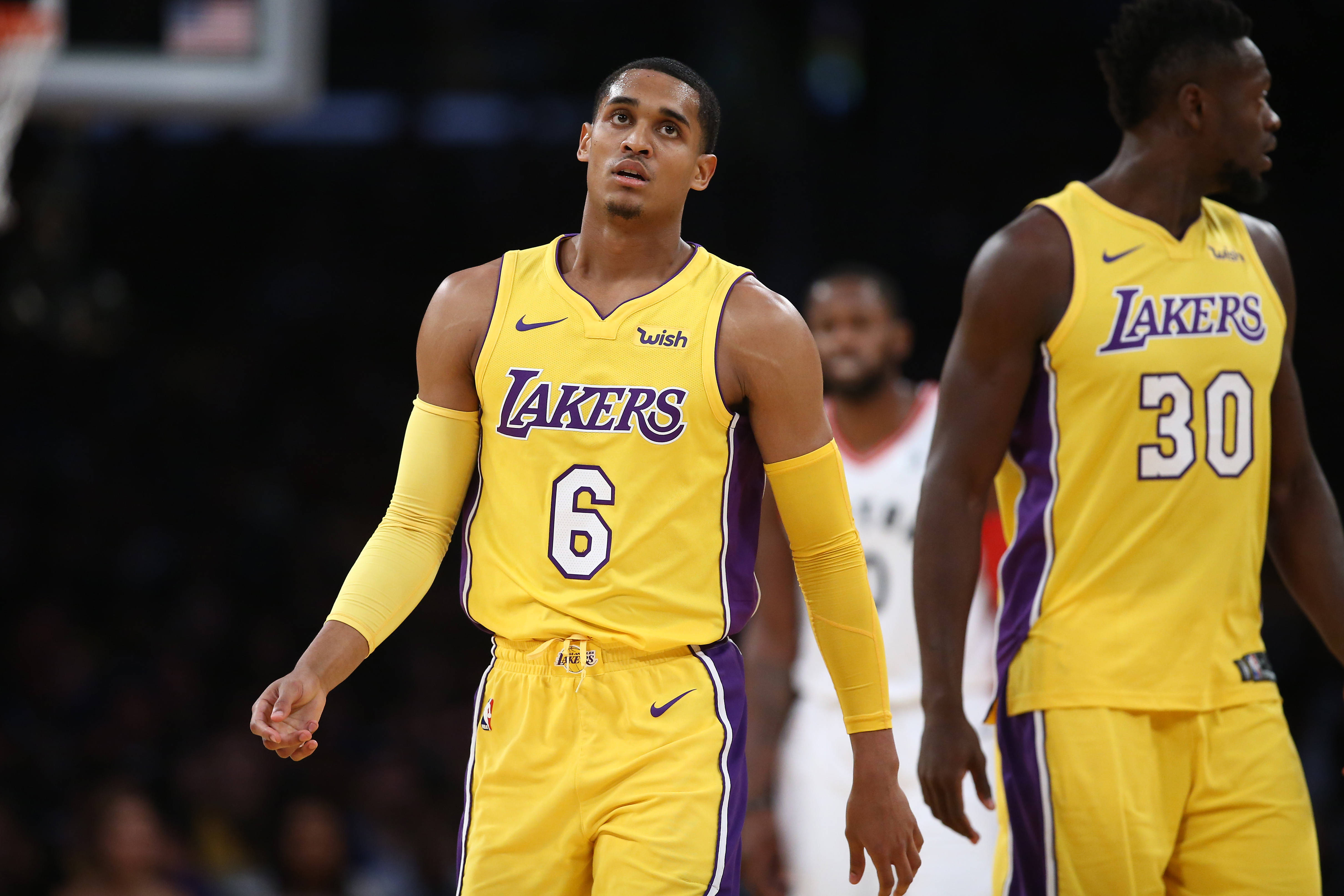 NBA 桌布 壁紙 — 兩名身穿黃色和紫色球衣的洛杉磯湖人籃球運動員在比賽中專注地站在球場上。