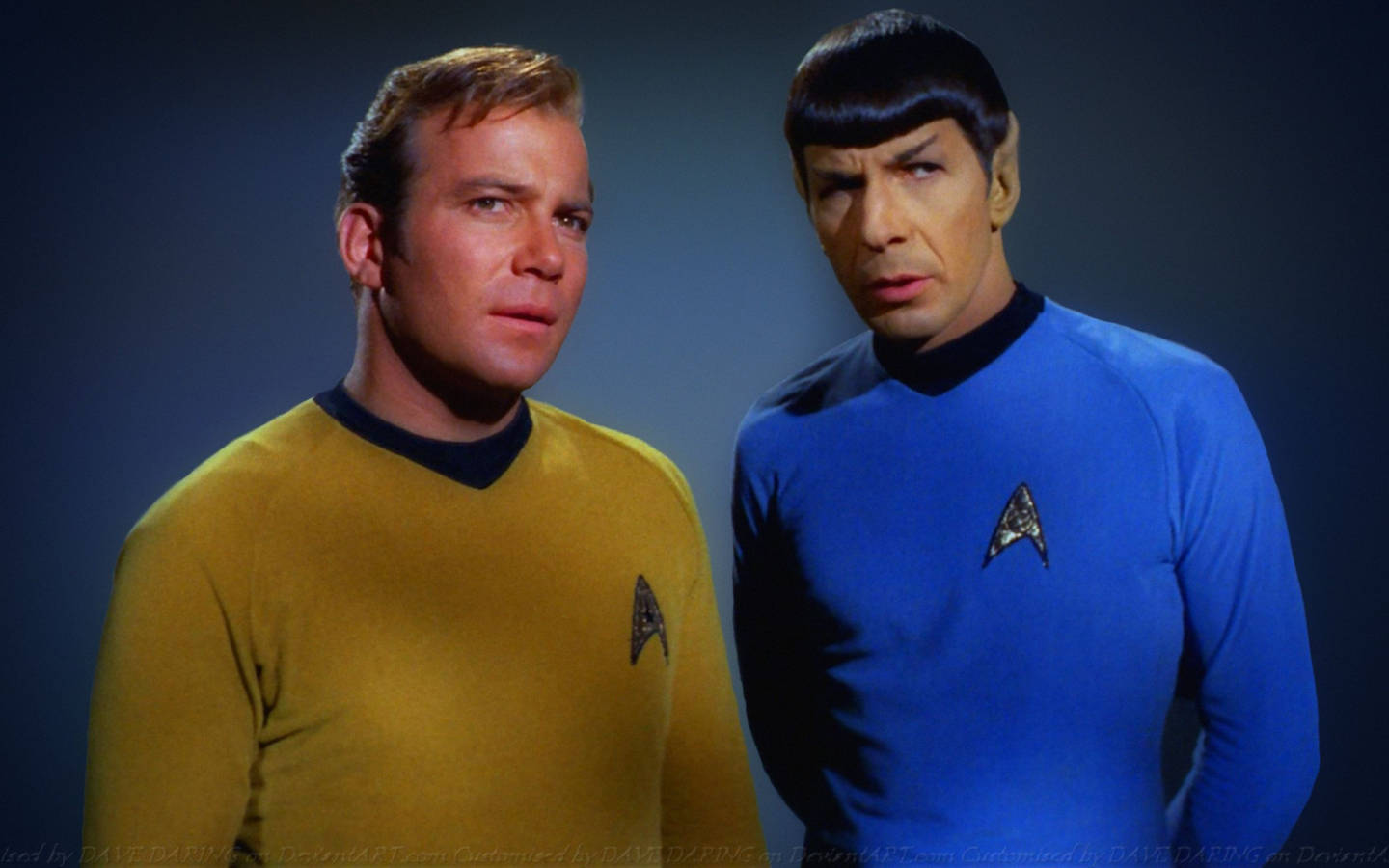 Spock 桌布 壁紙 — 兩名身穿黃色和藍色制服的星際爭霸戰船員並肩站在深藍色工作室背景前。