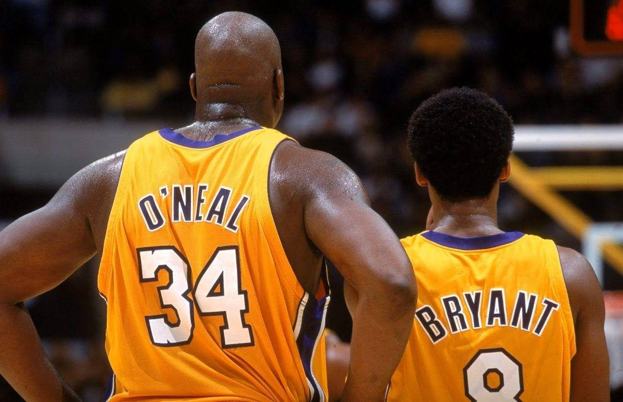 Shaquille O'neal 桌布 壁紙 — 兩名身穿黃色球衣的籃球運動員在球場上背對背站立，背景是模糊的人群。