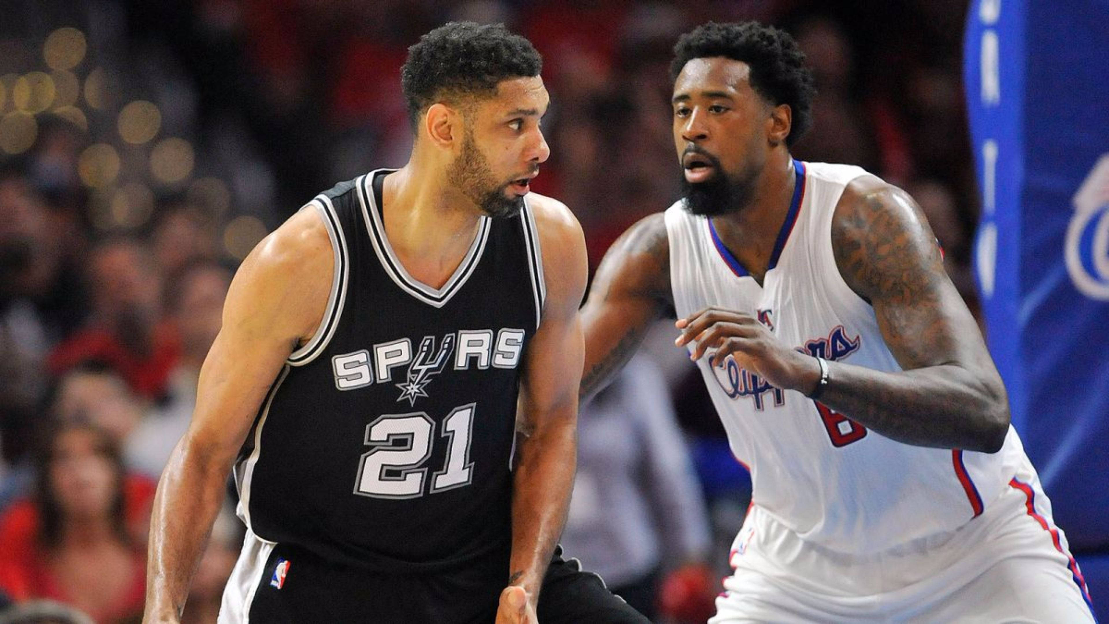 Tim Duncan 桌布 壁紙 — 兩名身穿黑白球衣的激烈籃球運動員在明亮的場館燈光下於一場激烈的比賽中對峙。