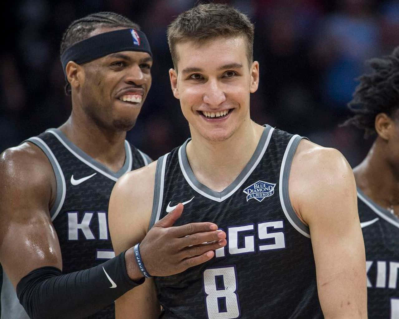 NBA 桌布 壁紙 — 兩名身穿黑色Kings球衣的籃球運動員在比賽中於球場上分享歡樂時刻。