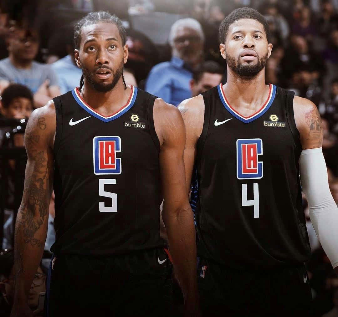 NBA 桌布 壁紙 — 兩名身穿黑色洛杉磯快艇隊球衣的籃球運動員並肩站在球場上，身後是模糊的人群。