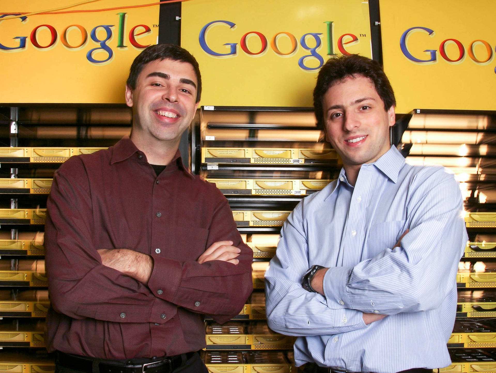兩名男子在Google伺服器機架前交叉雙臂微笑。 — Google Meet 壁紙