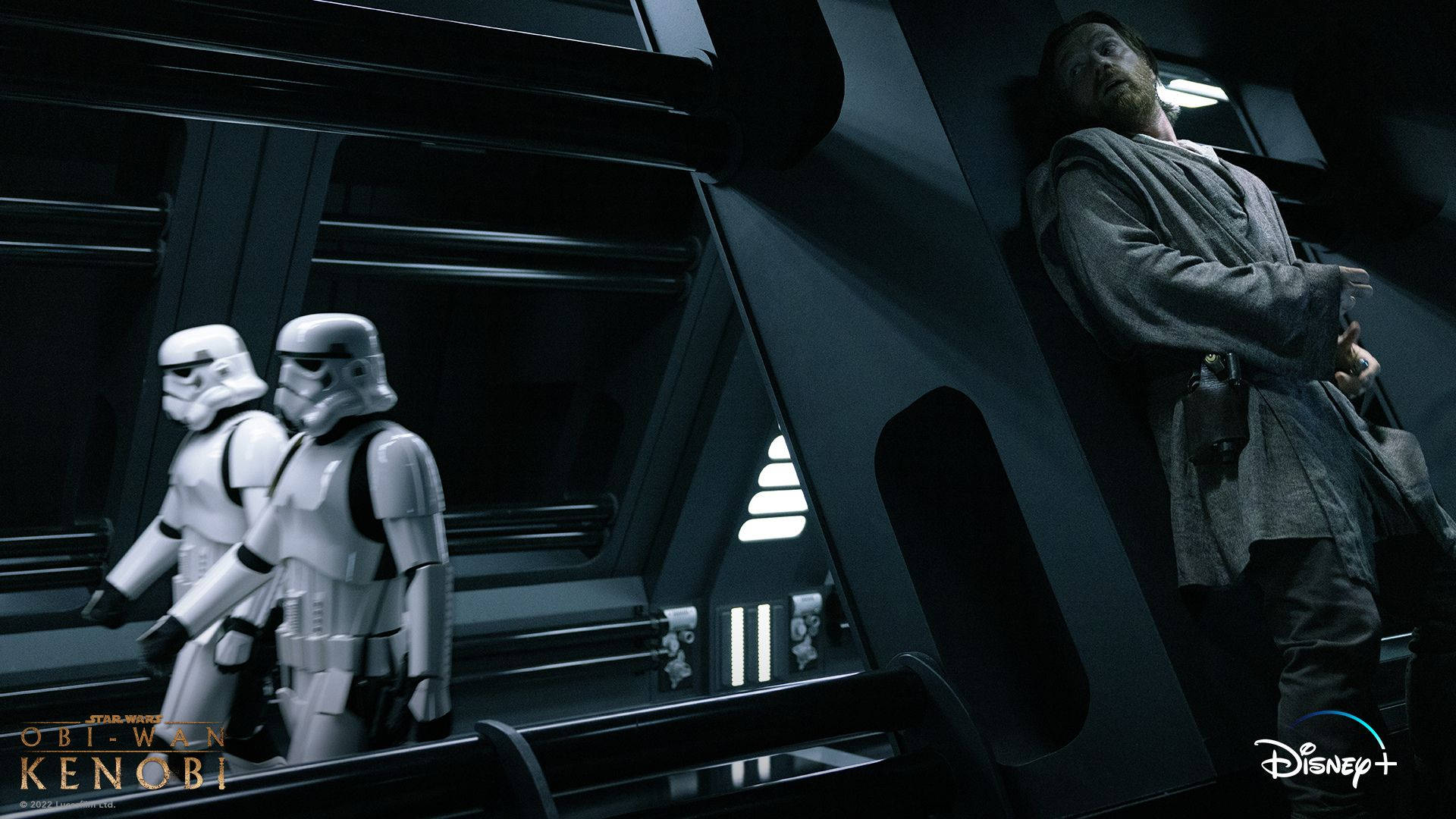 Kenobi 桌布 壁紙 — 兩名風暴兵在昏暗的未來風格走廊中保持警覺，歐比王·肯諾比則靠在牆上，形成緊張的對峙。