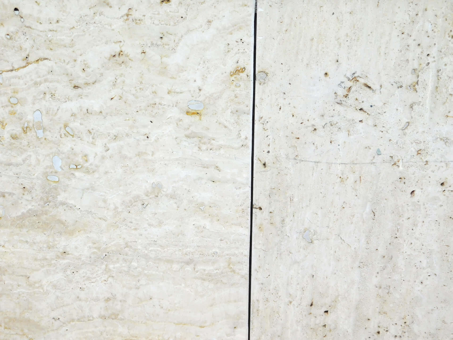 Marble Texture 壁紙 — 兩塊奶油色洞石面板以細黑色填縫線連接的特寫。
