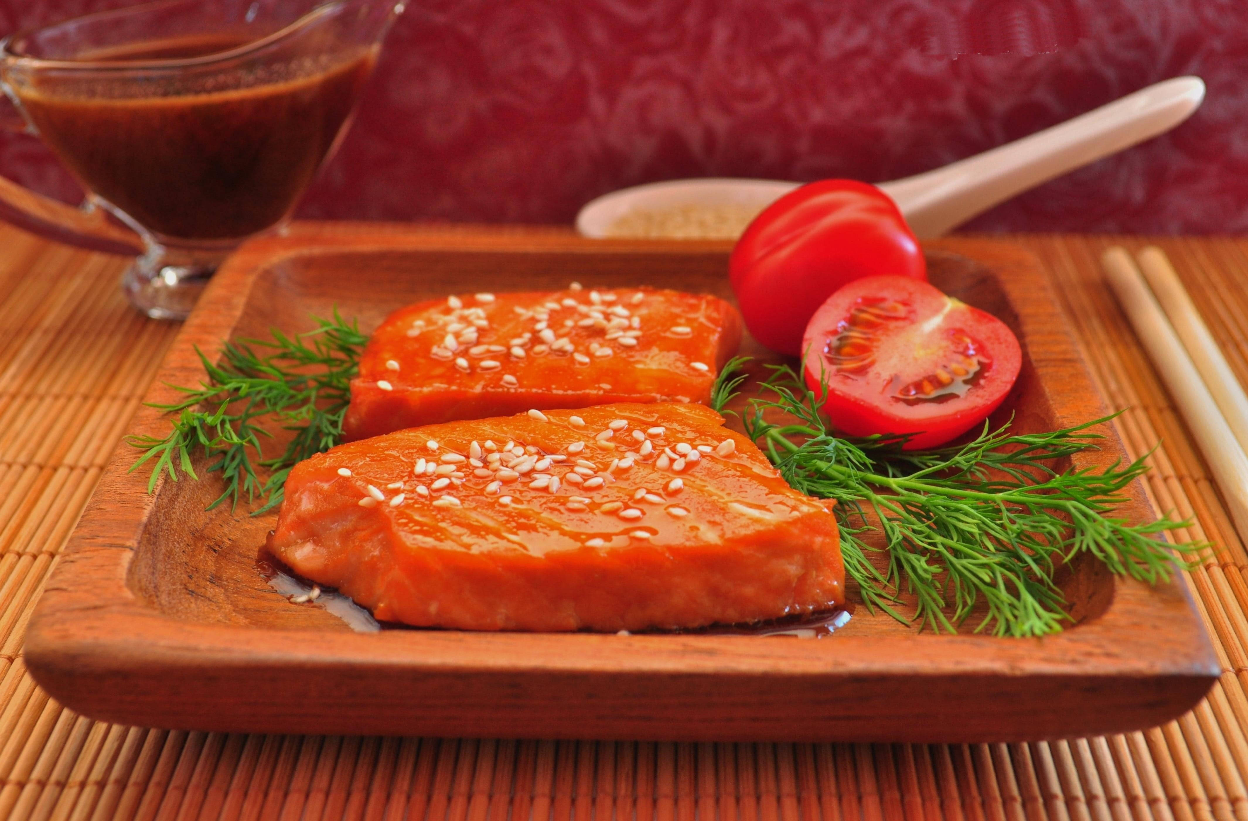 Delicious Food 桌布 壁紙 — 兩塊釉面鮭魚菲力，飾以芝麻、蒔蘿和番茄片，置於木盤上。