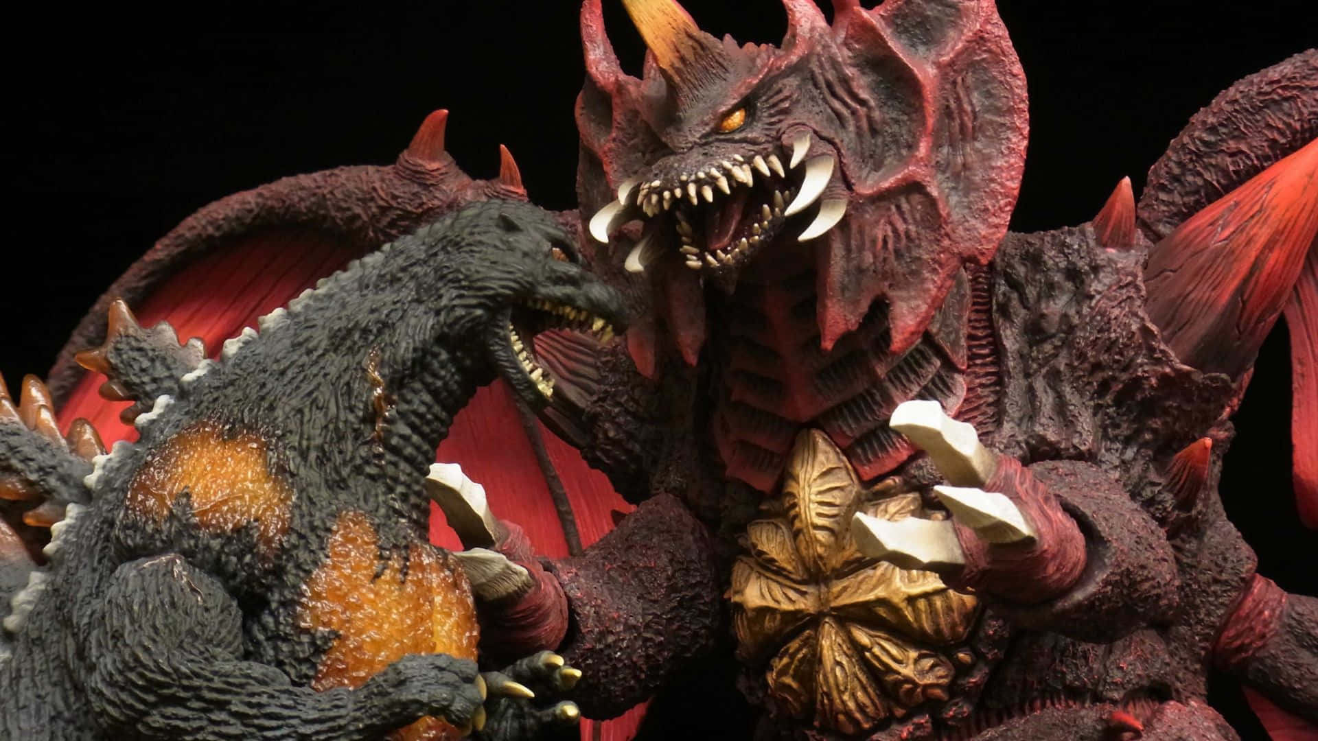 Godzilla Vs Destoroyah 桌布 壁紙 — 兩尊怪獸級巨獸雕像在黑色背景下以發光的眼睛和鋒利的牙齒戲劇性地近距離衝突。