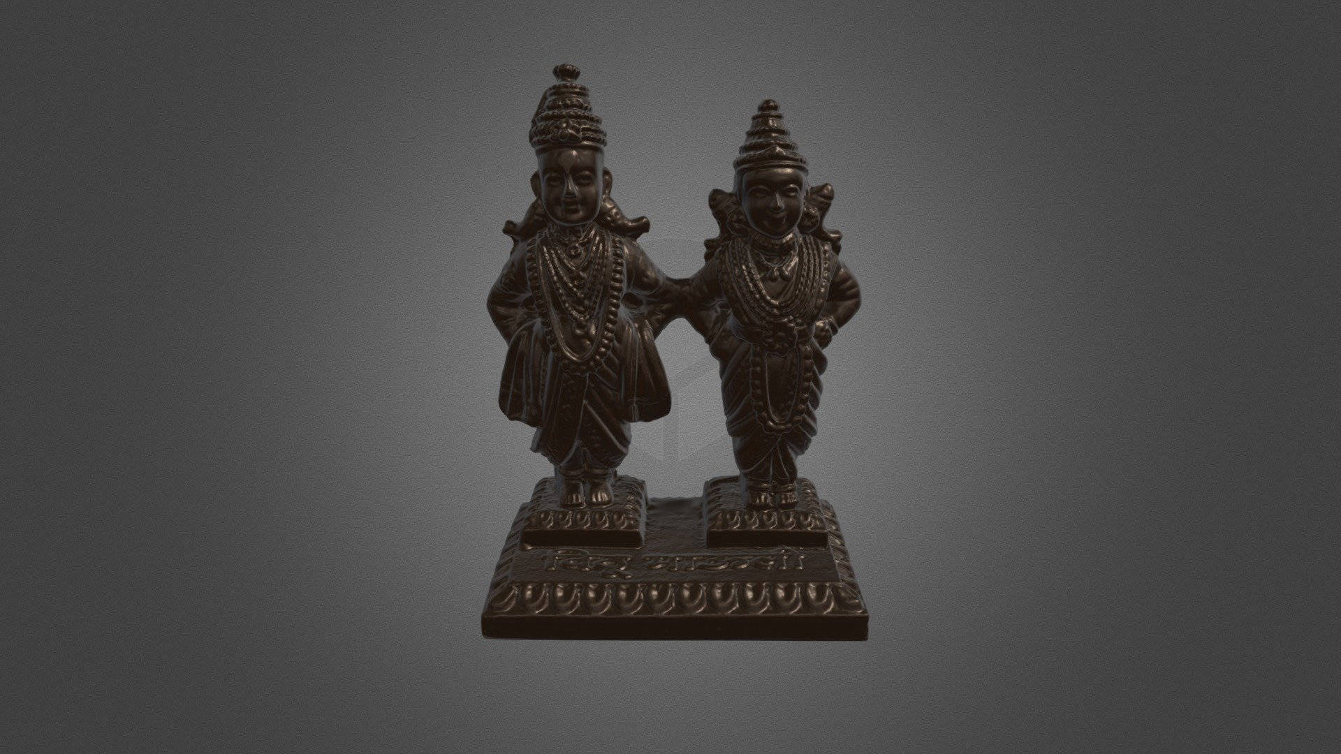 Indian 桌布 壁紙 — 兩尊精雕細琢的深色青銅雕像，微笑的人物穿著傳統服飾，並排站在華麗的底座上，背景為漸變灰色。