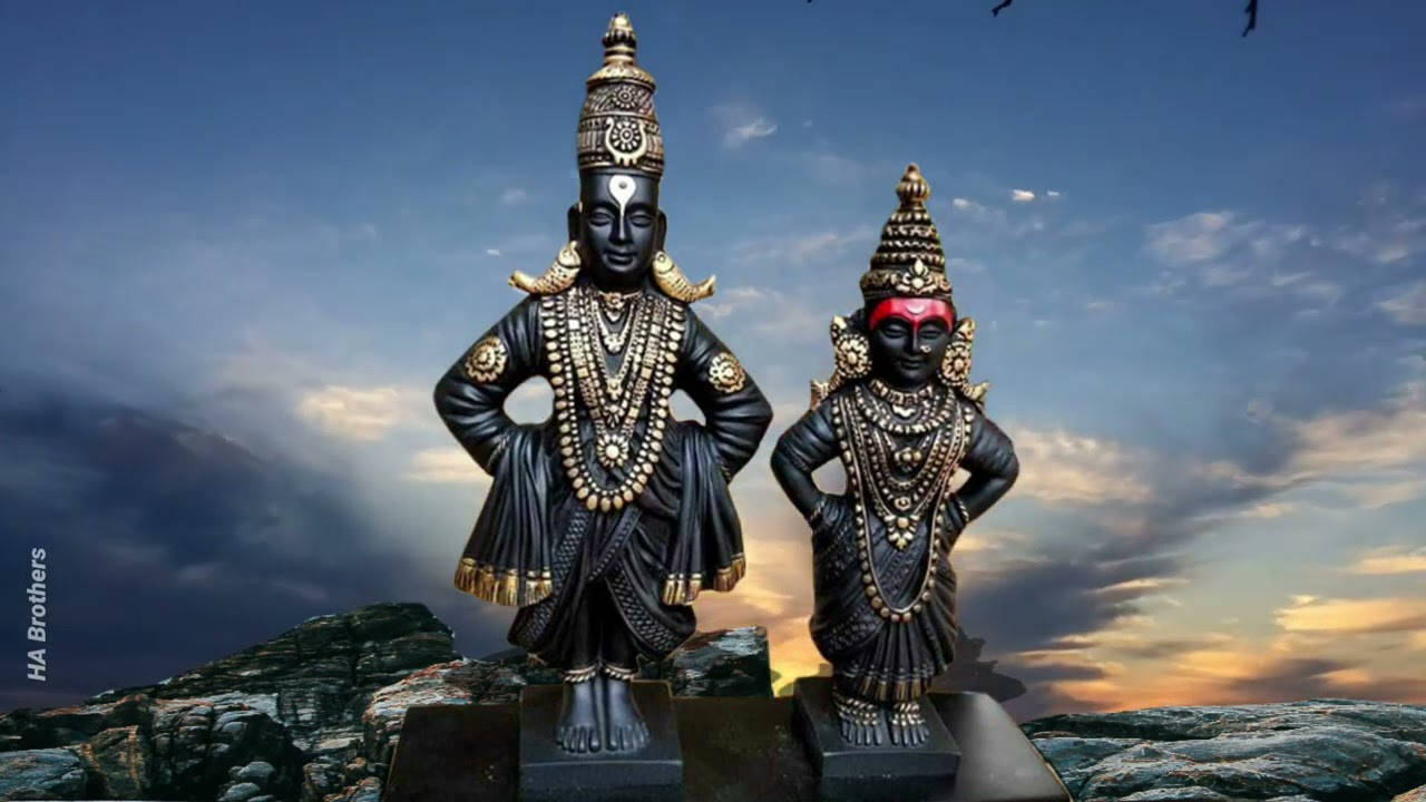 Indian 桌布 壁紙 — 兩尊華麗的黑金印度教神像在岩石地形上傲然矗立，背景是戲劇性的暮色天空。