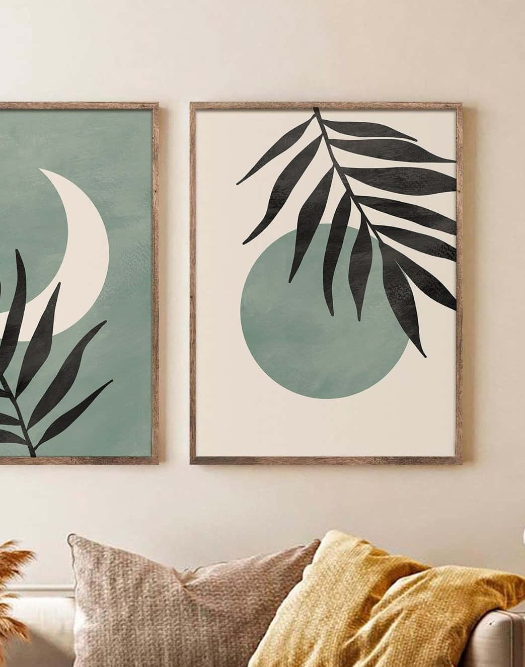 Minimalist Painting 桌布 壁紙 — 兩幅帶有黑色棕櫚葉和藍綠色圓圈的簡約風格框畫，掛在一張配有質感抱枕和芥末黃色蓋毯的舒適沙發上方。